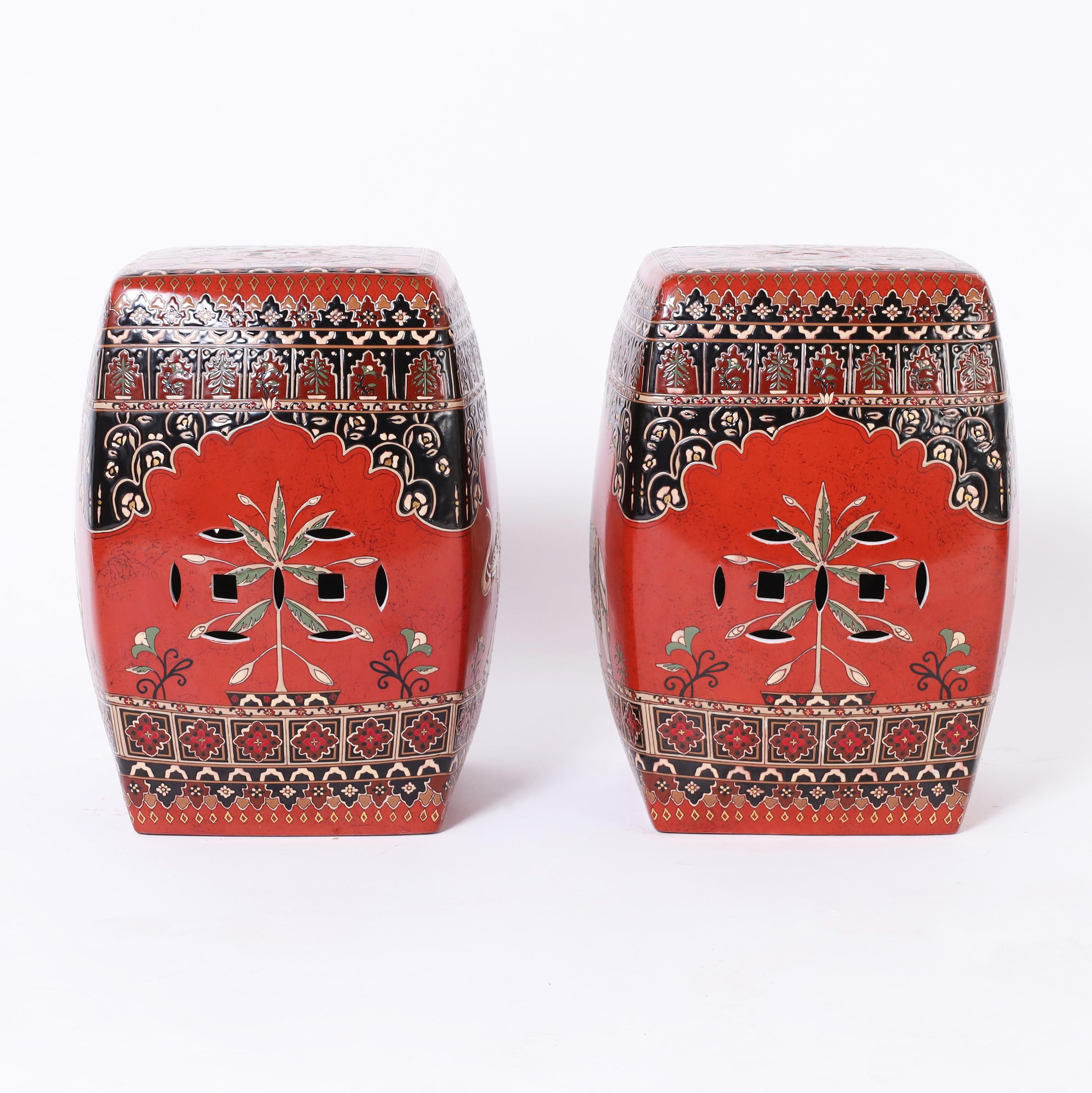 Striking pair of vintage Chinese garden seats with rare decorative appeal hand decorated with elephants on an alluring red background and floral and geometric borders. 