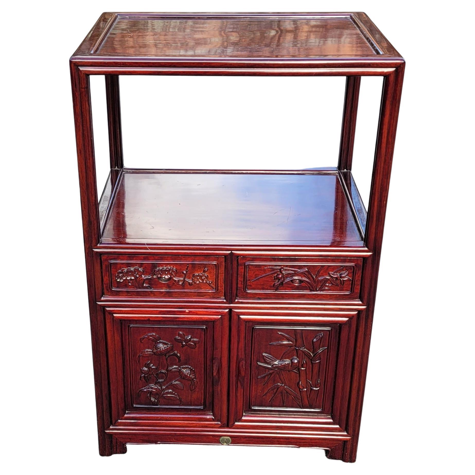An absolutely gorgeous pair of Chinese tiered teak carved side tables cabinets. Versatile use. May be used as side table s in the living room, family room or as bedside tables or any room. Feature two drawers and bottom double door cabinet. Carved