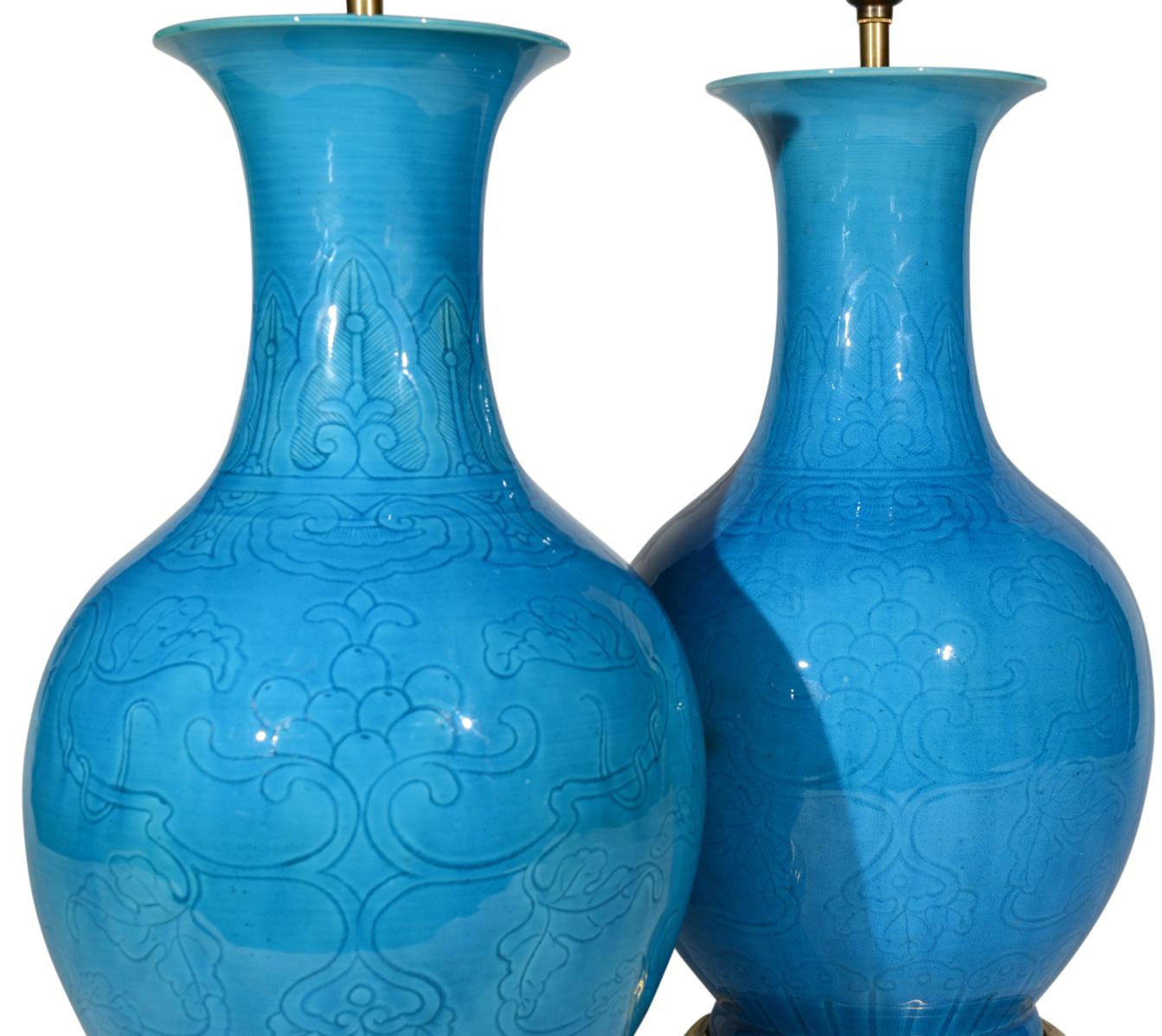 A very fine pair of late 19th century Chinese turquoise glazed baluster vases, each with narrow flared necks and incised with stylised lotus and foliate decoration, now mounted as table lamps with hand gilded turned bases.

Height of vases: 16 1/2