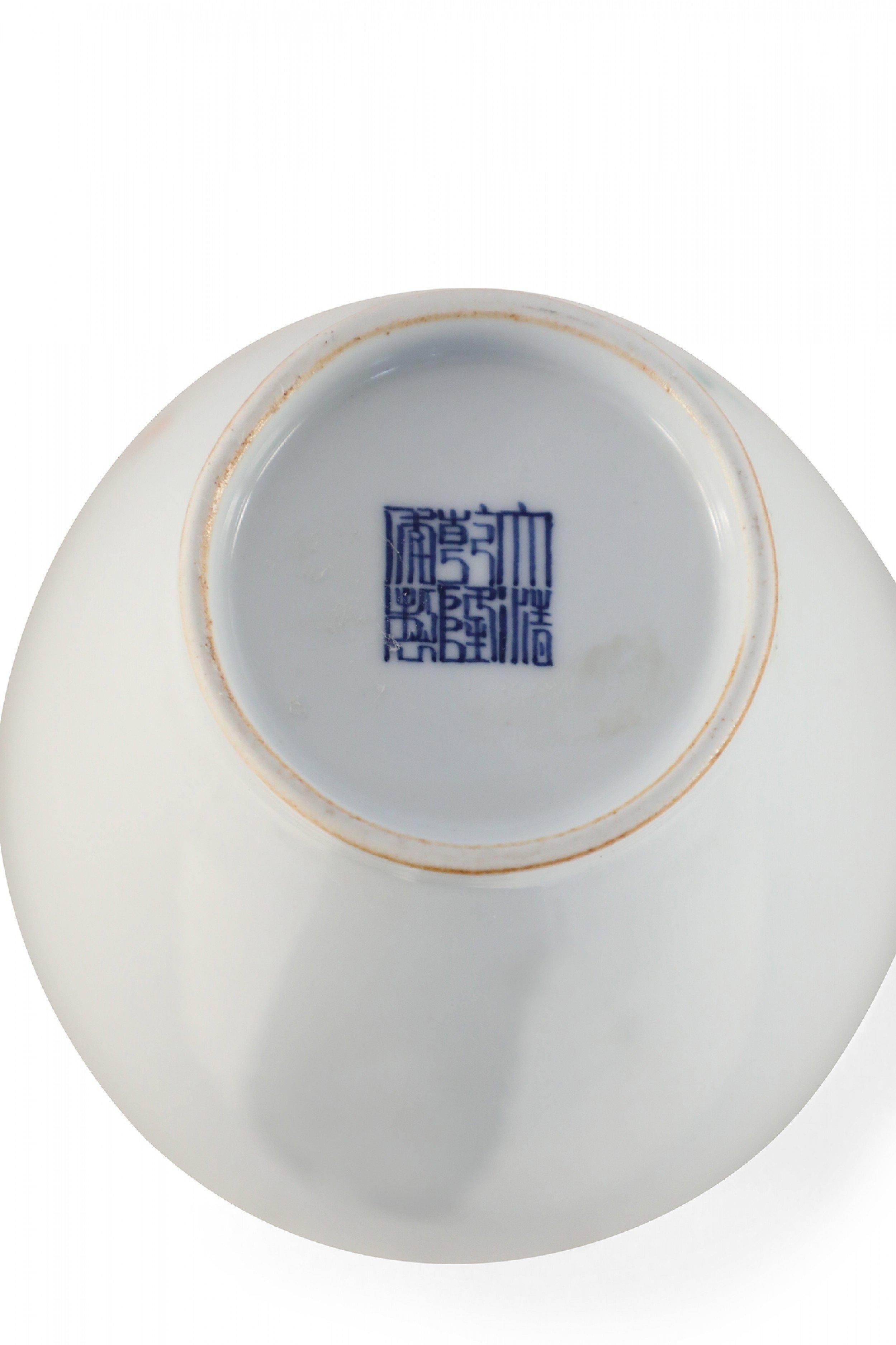 PAIR of Chinese white porcelain famille rose jars painted with verdant trees inhabitated by insects growing up and across the fronts and characters on the backs, finished with finial-topped lids (PRICED AS PAIR).
