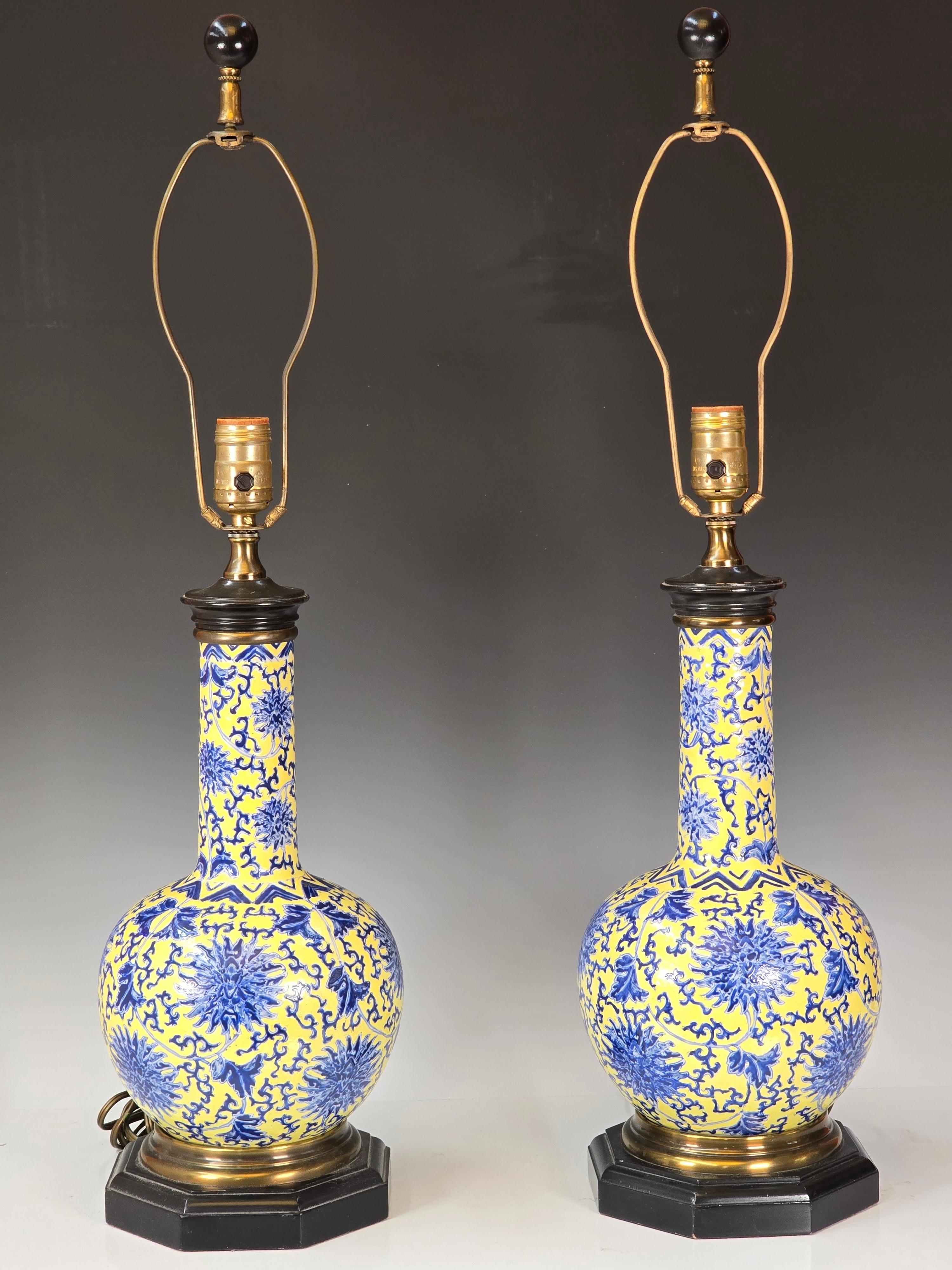 Magnifique paire de vases chinois transformés en lampes dans les années 1960.  Magnifique fond en émail jaune sur fond bleu et blanc sous glaçure, montures en laque et en laiton et épis de faîtage assortis. 