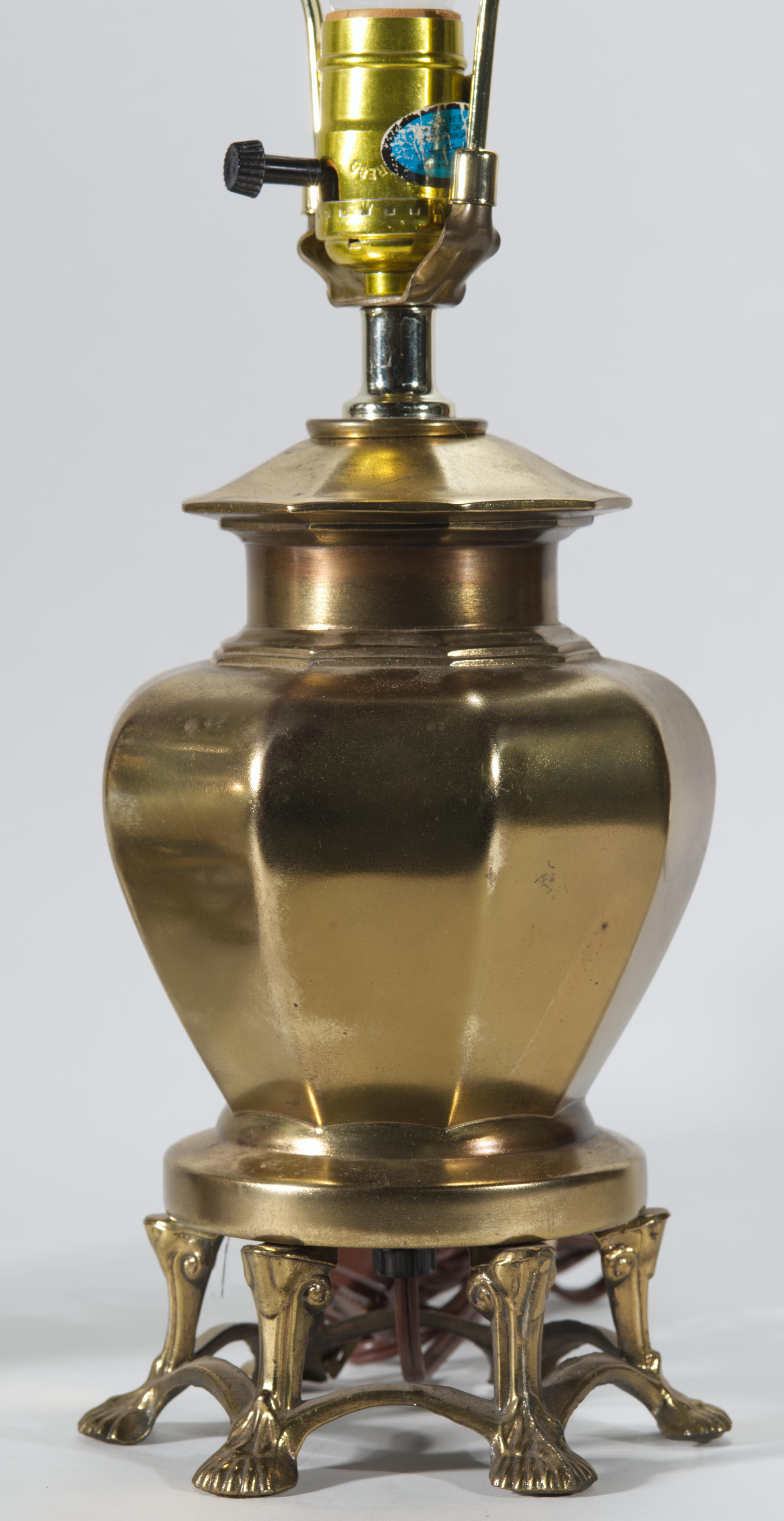 Vintage pair of cast bronze table lamps feature the classic ginger jar or urn shaped bodies mounted on footed pedestals. The ornate pedestals are standing on 6 highly detailed claw feet. The form of the lamps is reminiscent of table lamps by
