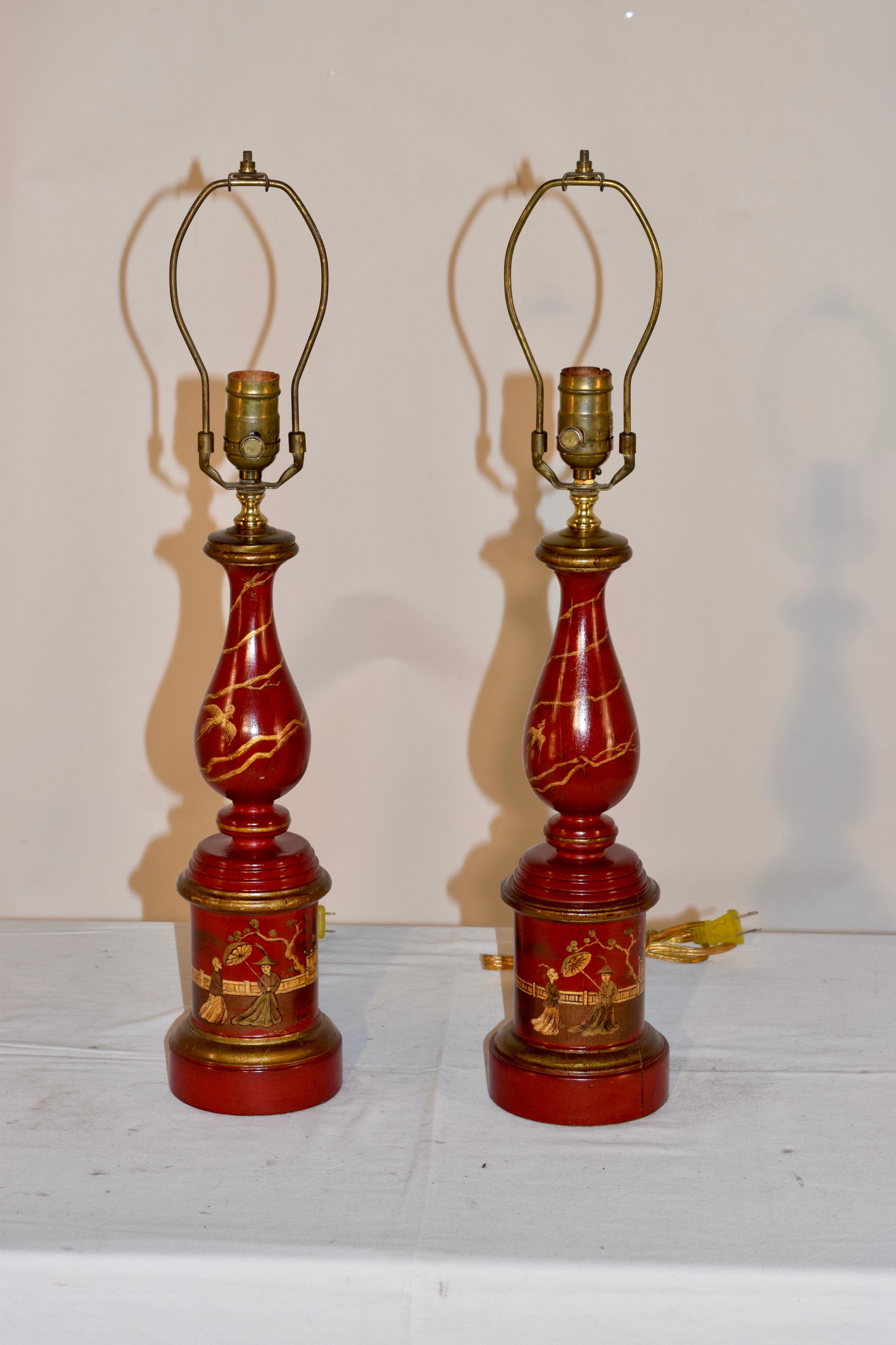 Pair of chinoiserie table lamps in a luscious red with hand painted decoration in shades of gold and brown.