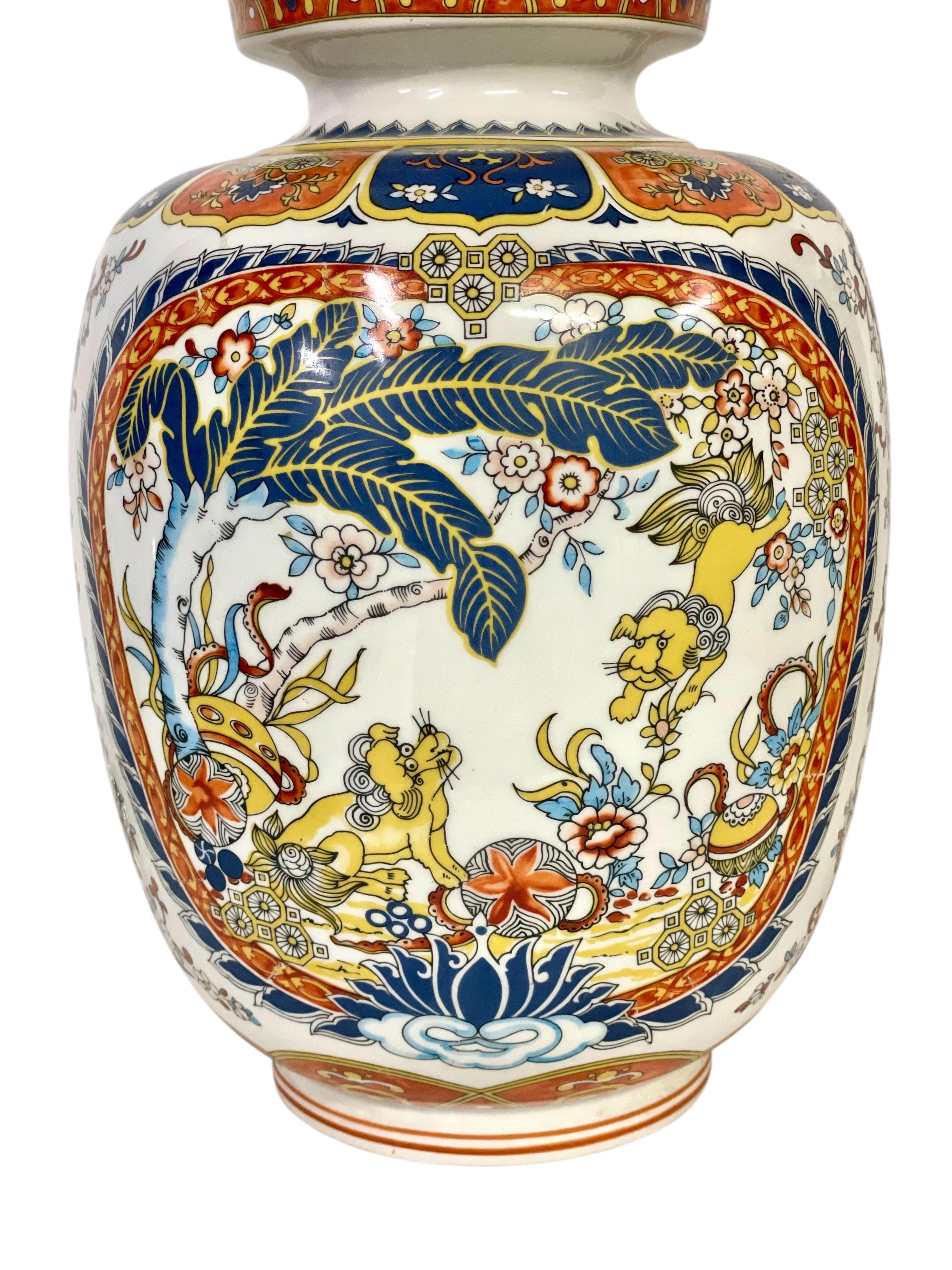 Questa coppia di squisiti vasi di cineserie con coperchio, o vasi di zenzero, presenta un'intricata decorazione policroma dipinta a mano con fiori e cani foo - creature mitiche simili a leoni che simboleggiano prosperità e successo - e un classico
