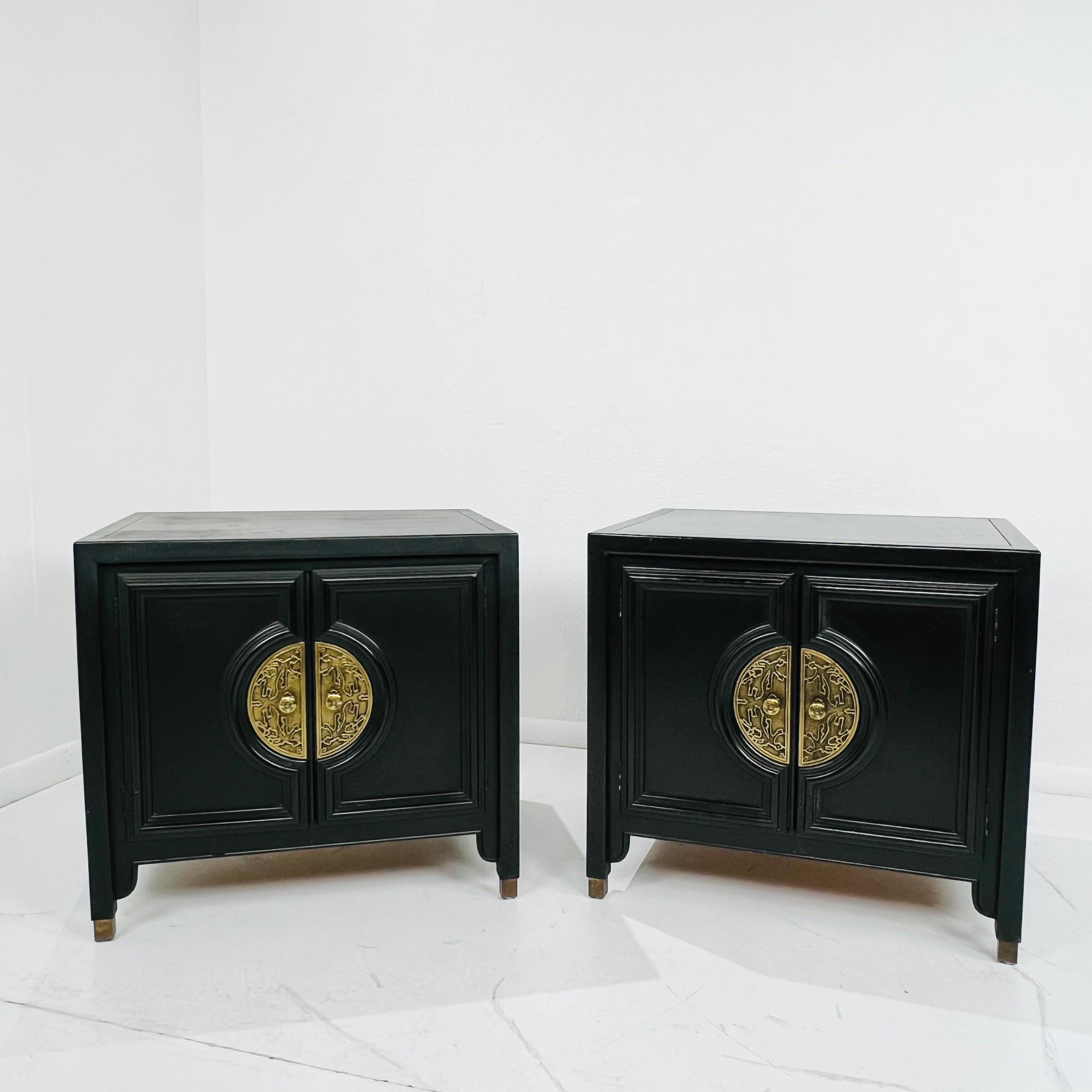 Pair of Chin Hua nightstands by Century Furniture. Ebonized cases with brass hardware and brass-tipped feet. Open cabinet space with shelf. Good structural condition with some cosmetic imperfections, including scratches/scuffs and damage to top
