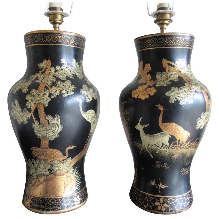 A beautiful pair of Chinoiserie papier mâché table lamps, in lacquered black with gilded oriental design, a decorative scene of a fir tree, stork and deer, the top and base of the lamps are finished with a gilded pattern. Made from lacquered paper,