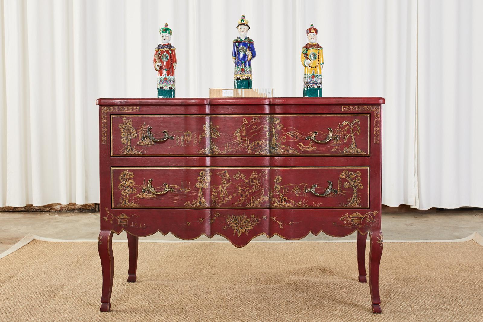 Gorgeous pair of English chinoiserie style commodes or chests. Featuring a hand-painted parcel gilt decoration of idyllic Asian scenes against a dark red ground. Designed by Amy Howard collection. The chests have a serpentine shaped case in front