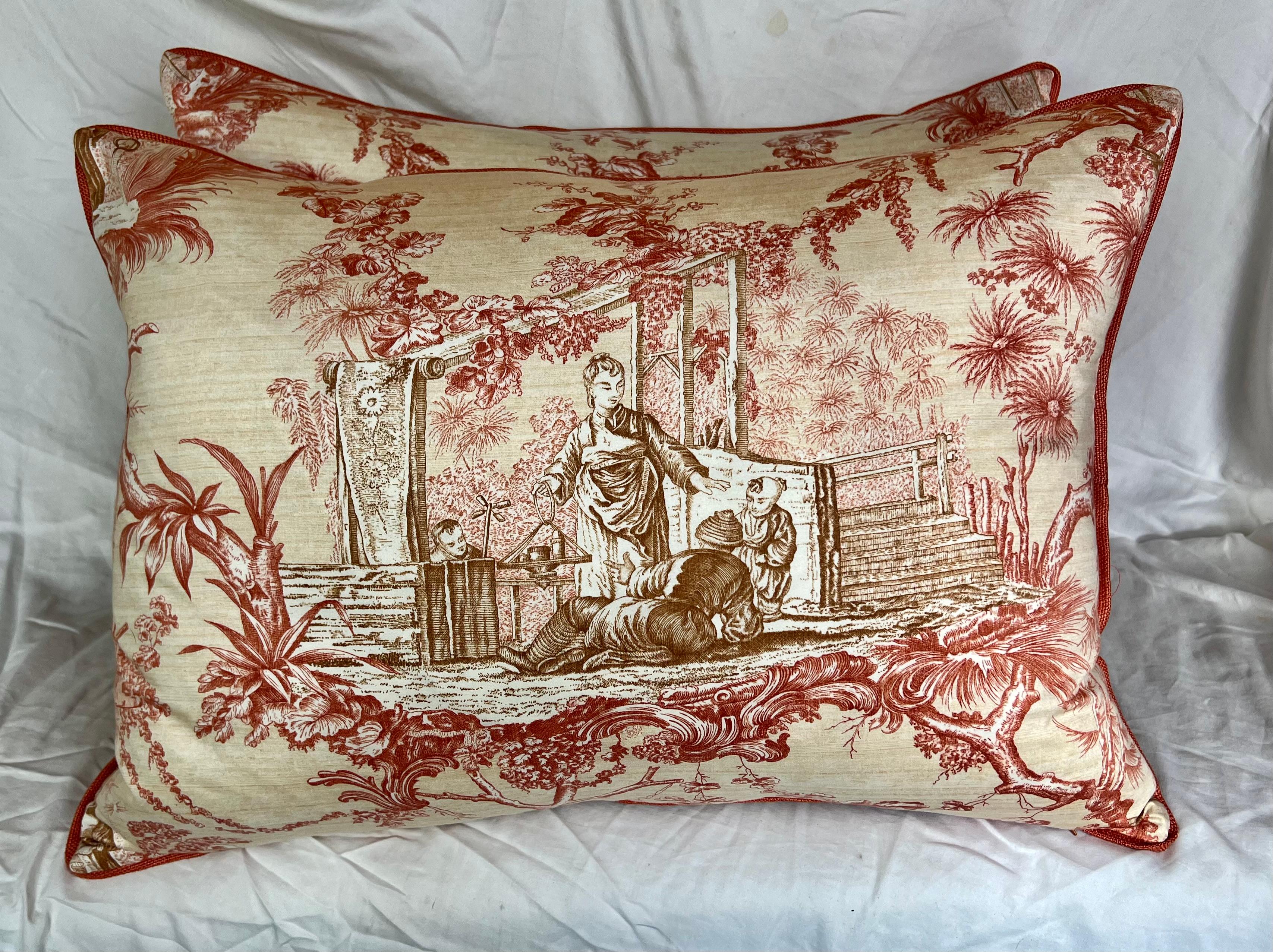 Custom chinoiserie-style patterned pillows are absolutely captiviating.  The scene includes a group of people engaged in discussion amidst red flowers and foliage, that creates a rich and immersive visual experience.  The coordinating linen on the