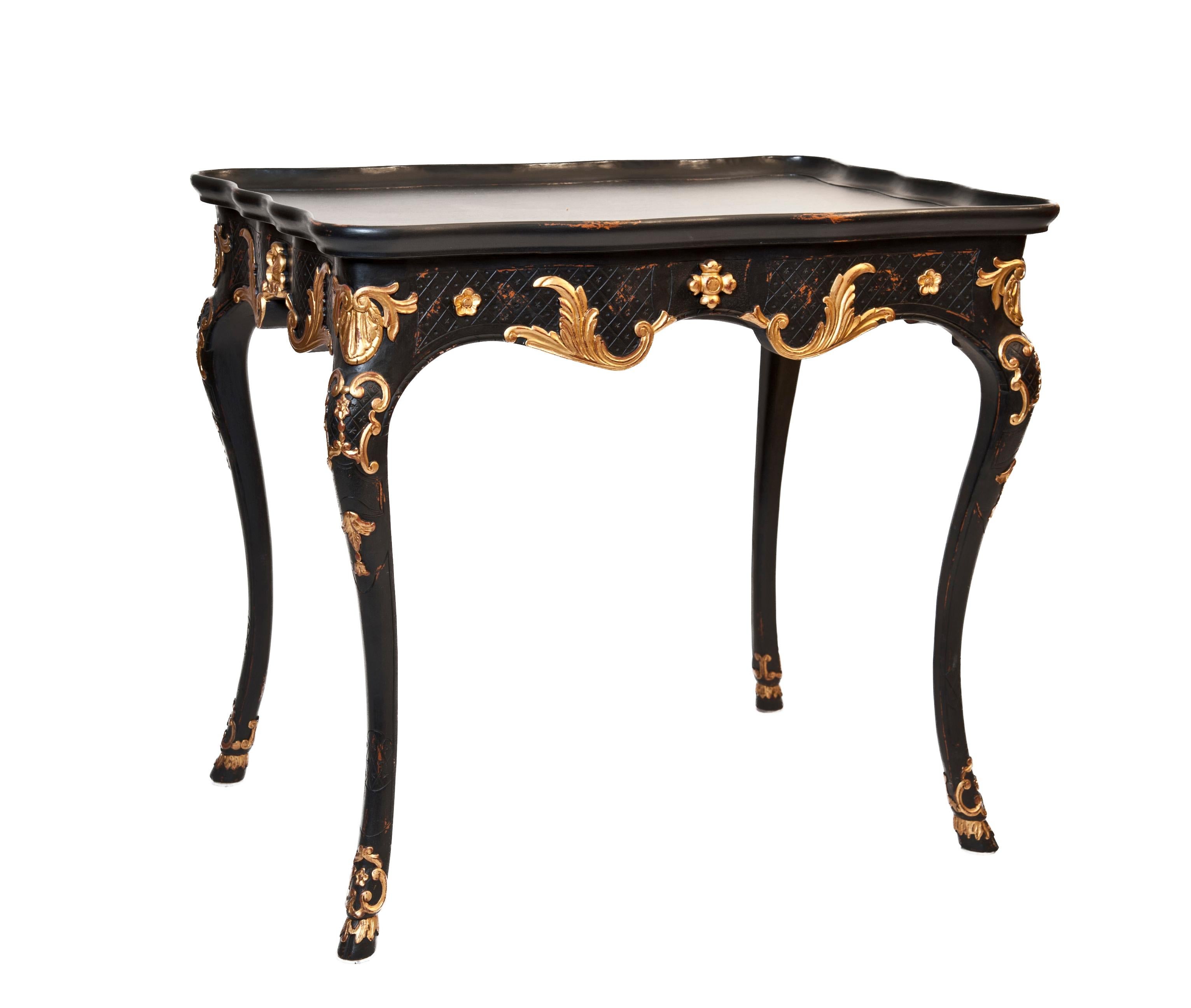 French, 20th century pair of Louis XV style, black chinoiserie tray tables, each with a hidden pull-out drawer. Ebonized with gilt detail, these end tables are a beautiful addition to a room, the satin finish adds a touch of luxury and a touch of