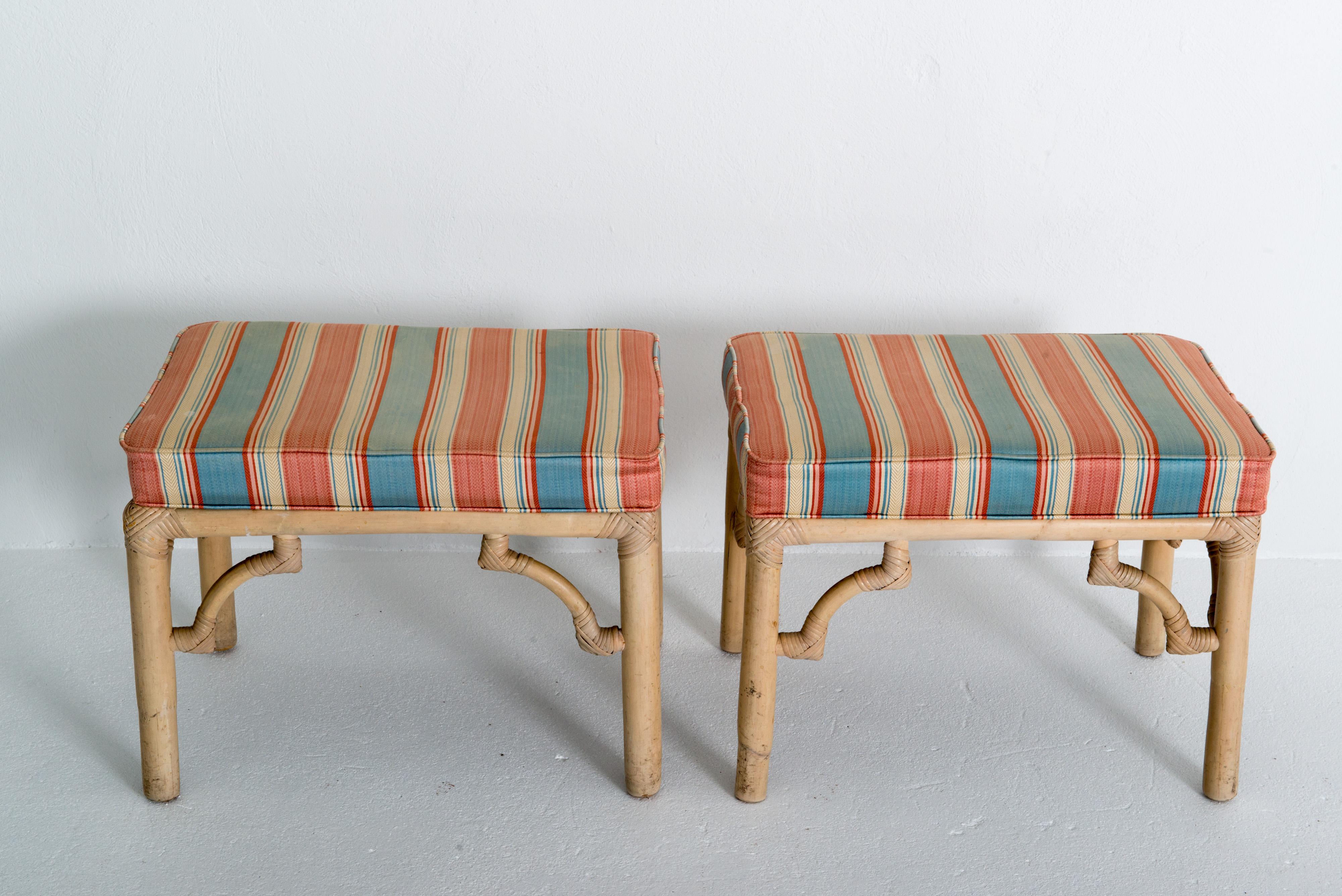 This is a pair of McGuire style benches upholstered with attached box cushions on rectangular chinoiserie rattan bases. 1960s era. In very good condition.