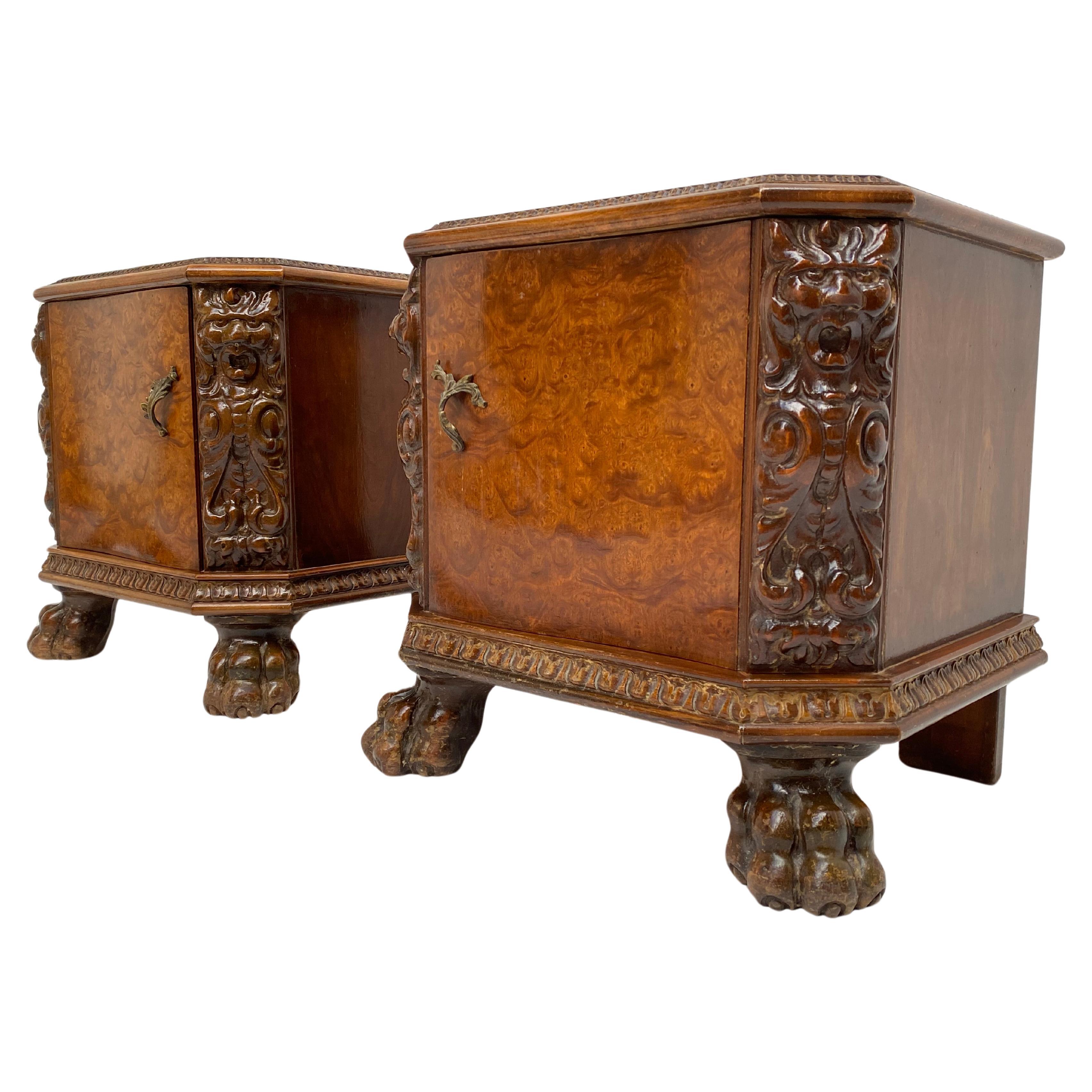 Pair of nightstands in a mixed Chippendale / Baroque style

Lion head and paw feet carved in Walnut and the doors finished in Burl veneer 

Brass filigree and door handles 

There are brass corners to the backside of the top indicating these
