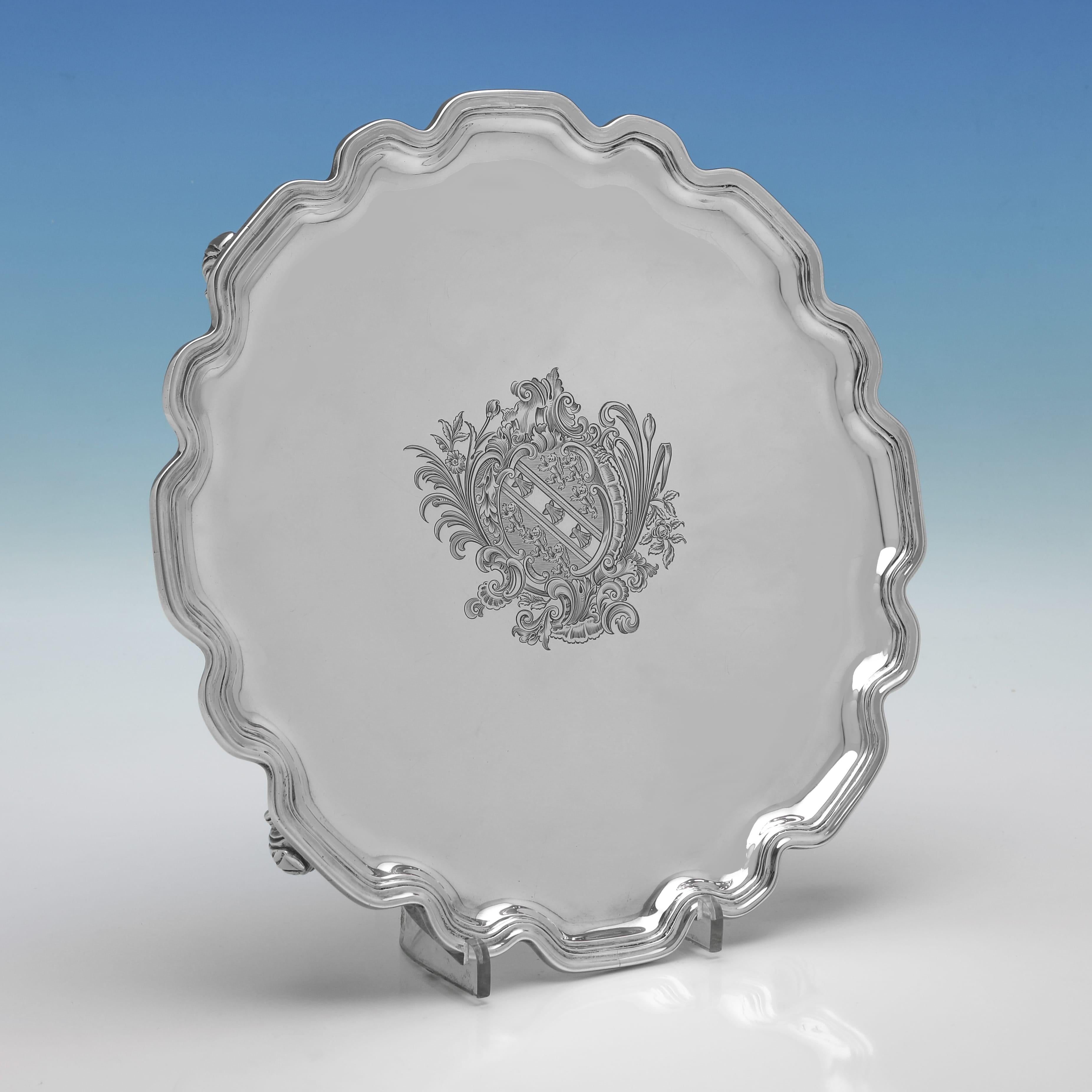 Dieses hübsche, 1939 in London von Crate & Mansell gepunzte Paar Sterlingsilber-Salben hat Chippendale-Ränder, gravierte Wappen in der Mitte und steht auf vier gegossenen Schneckenfüßen. Jeder Salver misst 12