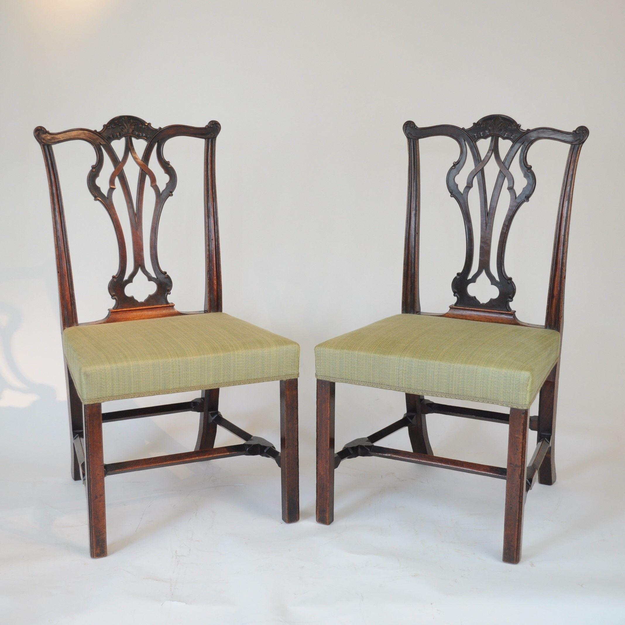 Fine pair of mid 18th century Mahogany, Chippendale inspired side chairs with carved serpentine cresting rails above leaf-carved open splats, with over-stuffed seats and standing on square chamfered legs with unusual square section stretchers set at