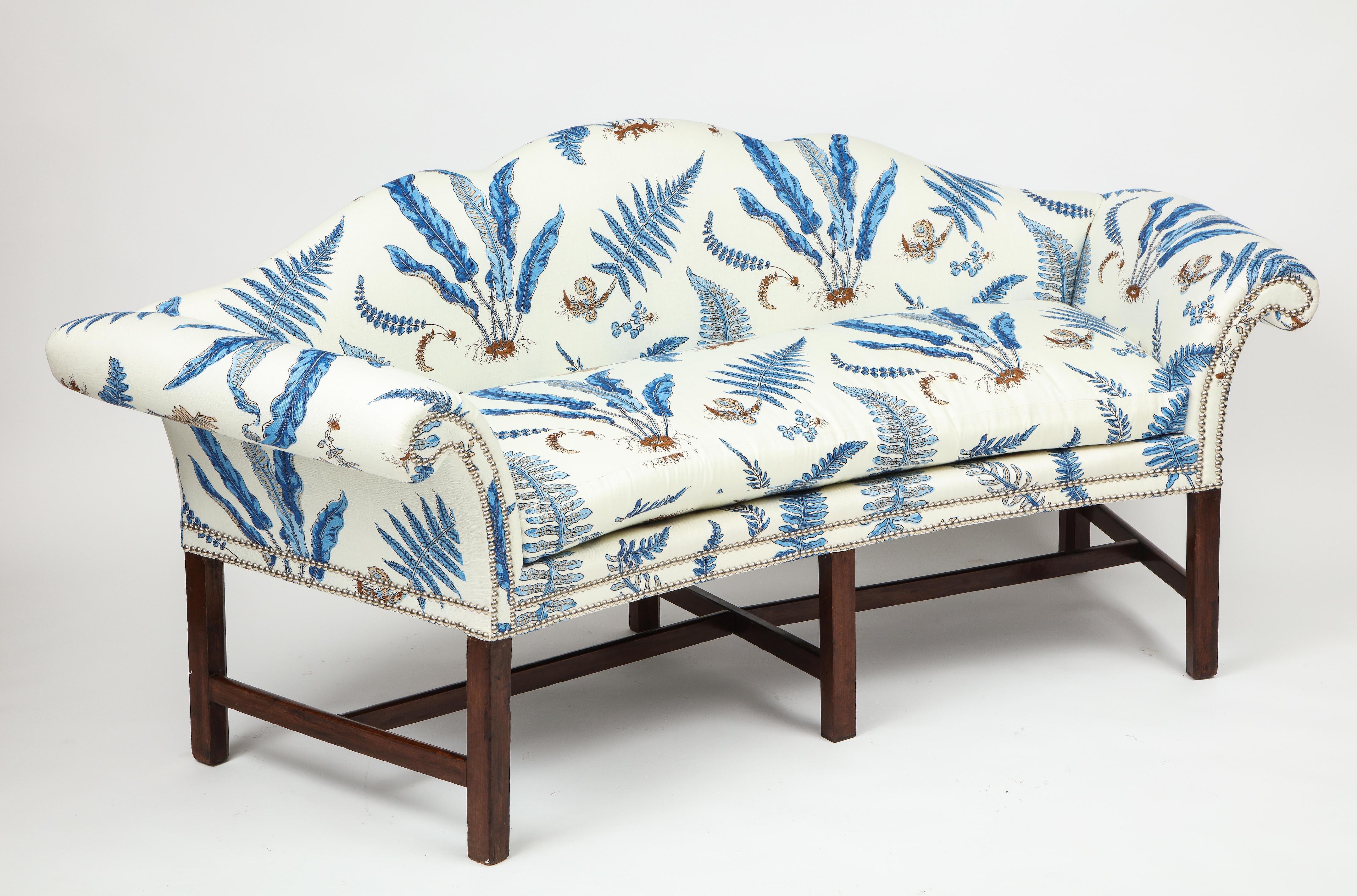The serpentine back and outscrolled arms are particularly graceful as is the overall incurved form. On straight legs with H-form stretchers. Each newly upholstered in Bakers Ferns linen with silvered nailheads.