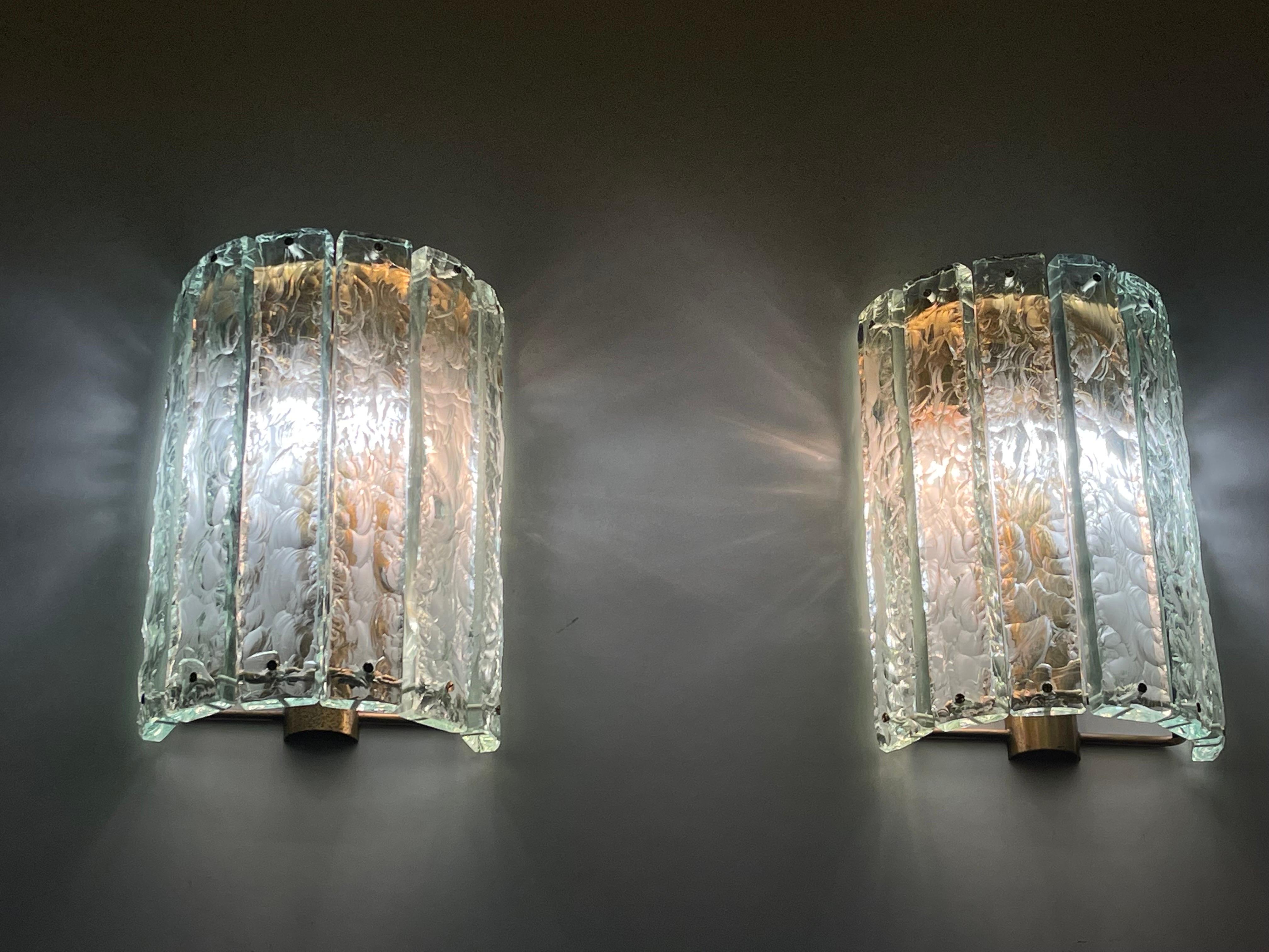 Pair of Fontana Arte sconces by Max Ingrand, based on model 2448 ceiling fixture. Six hand chiseled crystal diffusers around a brass demilune structure. 
Socket: each 4 x E14 for standard screw bulbs.
(Two pairs available)
