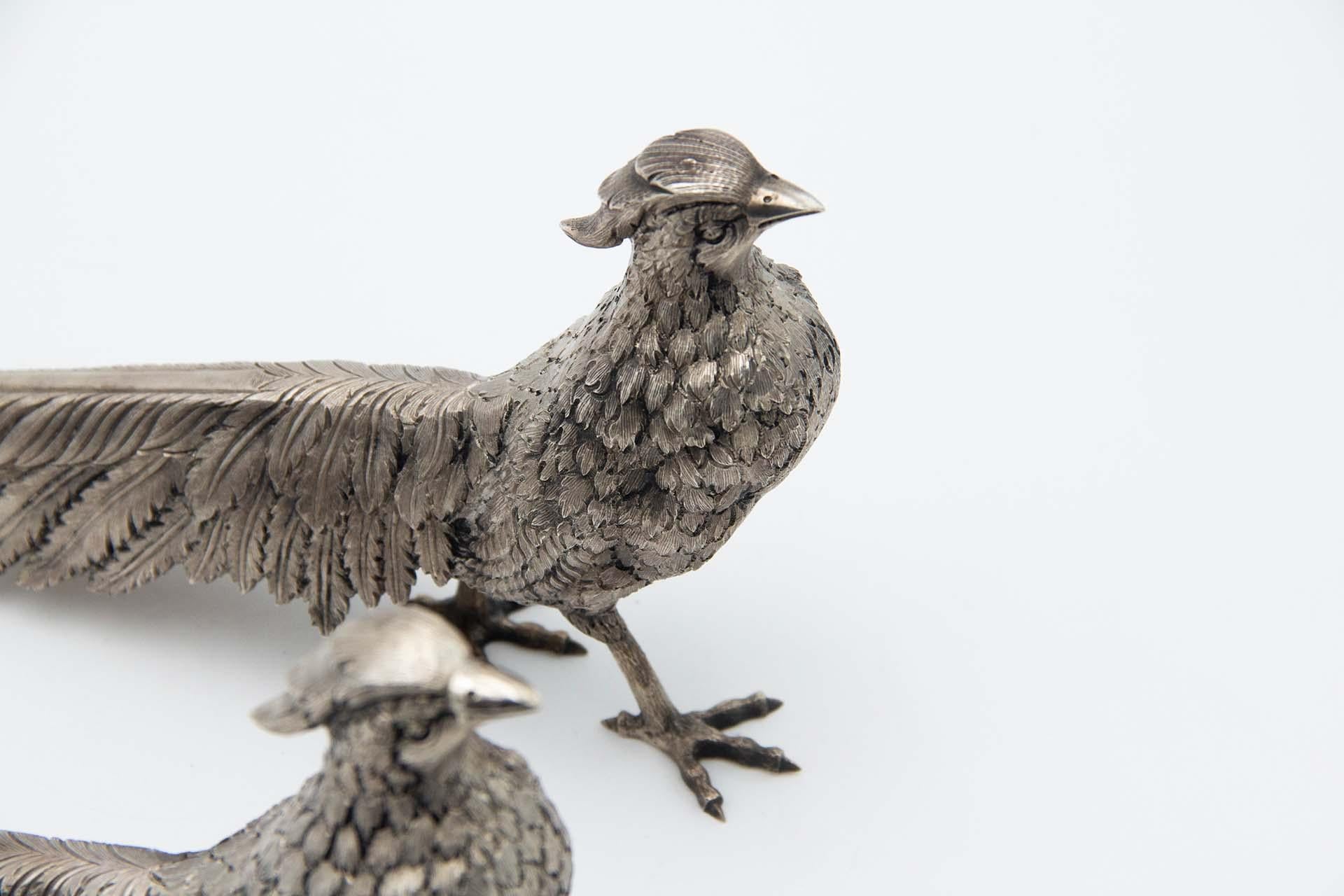 Description: Pair of chiseled silver pheasants, profusely embossed. Metal: Silver. Origin: Portuguese. Mark: standing eagle. Weight: 1247.47 grams. Dimensions: 28.5cmx14cm. Content: 833/1000. Assay Mark: Yes. Additional information: Good condition.
