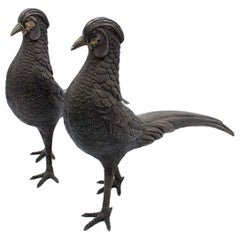 Pair of chiseled silver pheasants with long tails and profusely embossed shapes