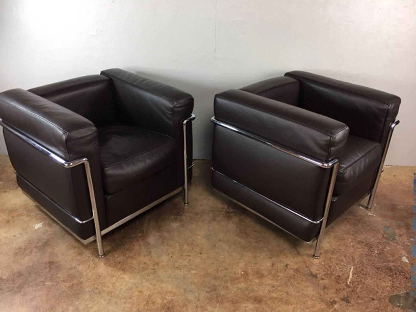 Superb pair of Le Corbusier LC2 club chairs in chocolate brown leather by Cassina for Knoll. Down filled seat cushions. Chairs are tagged on the bottom. 

Measures: Seat height is 18