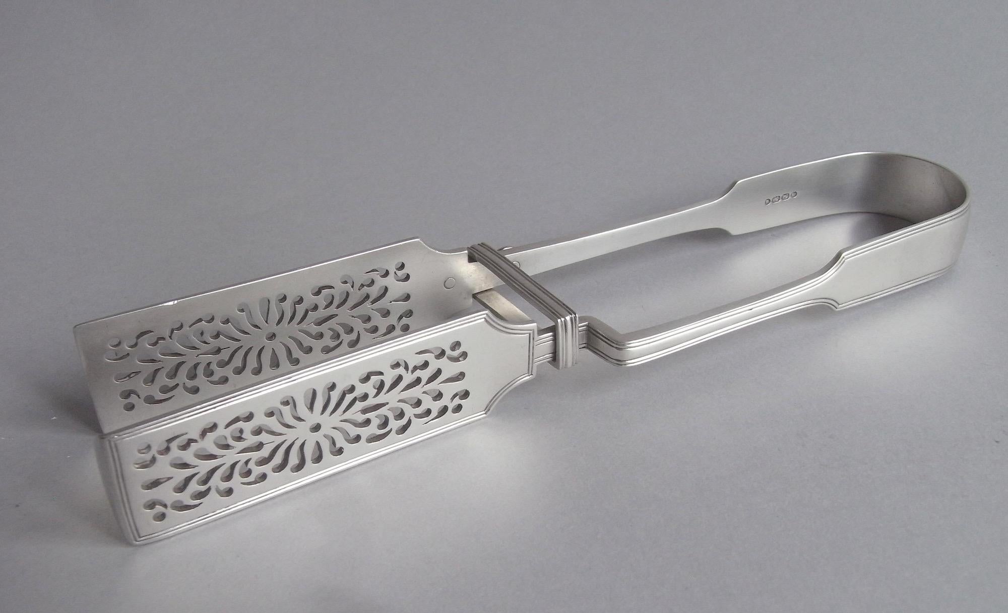Un par de pinzas muy finas fabricadas en Londres en 1854 por George Adams.

Las pinzas están modeladas en forma de violín, con amplias empuñaduras rectangulares perforadas con volutas. La parte superior arqueada muestra una liga del regimiento