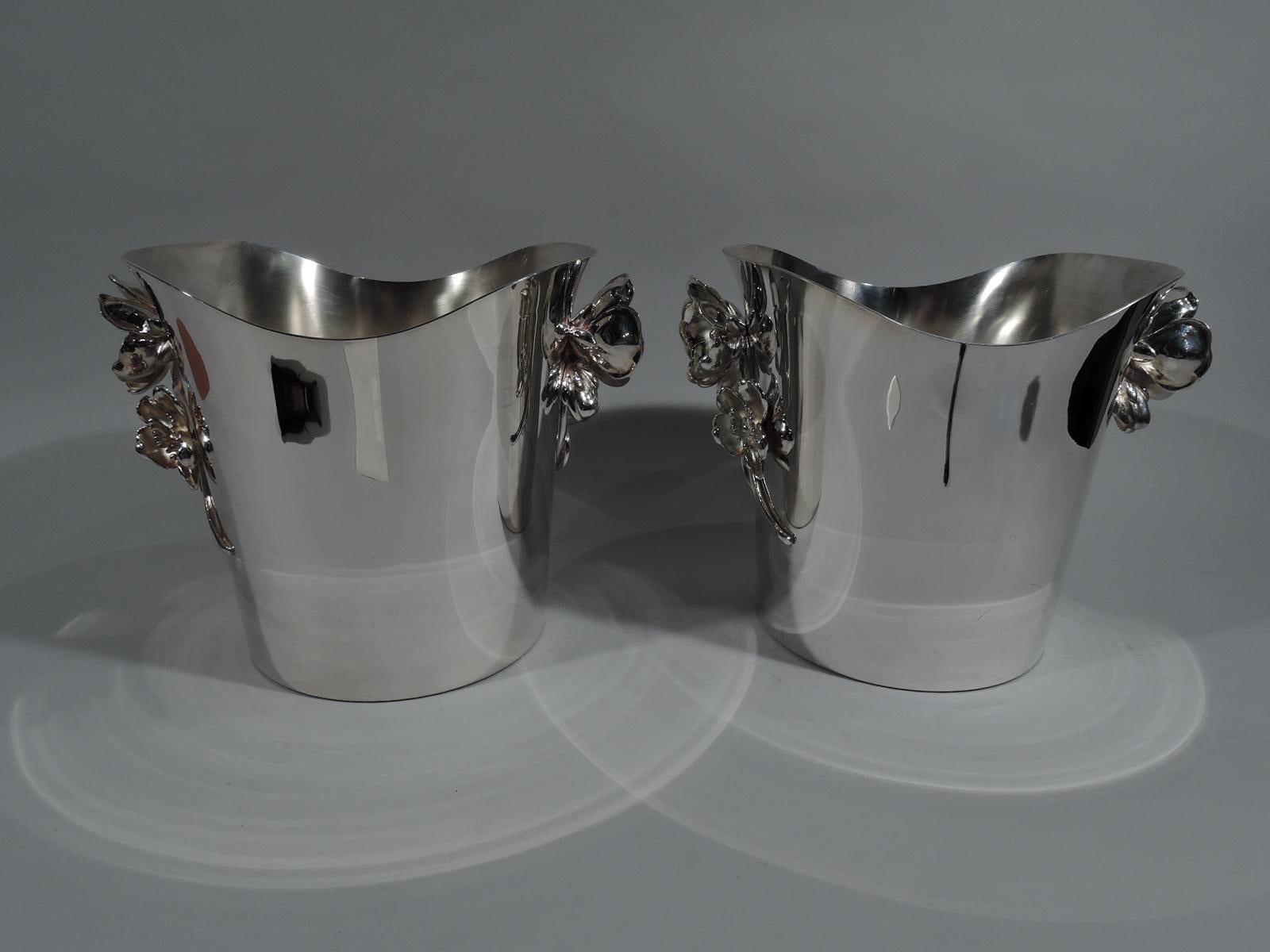 Pair of Art Nouveau silver plate champagne buckets. Made by Christofle in France. Each, oval with straight and tapering sides and swooping asymmetrical mouth. Applied side handles in form of two flower heads on one scrolled stem. On front in low