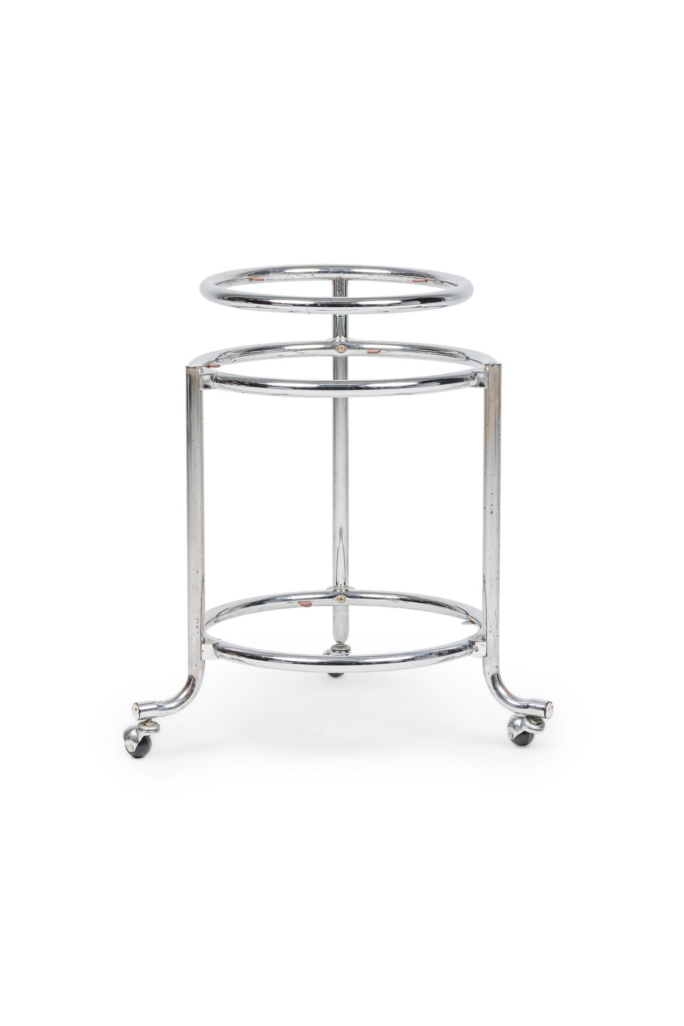 Pair of American Mid-Century Chrome Round Rolling Swivel Side Tables on 3 casters having a bottom and table top shelf under a suspended smaller shelf (Attributed to GILBERT ROHDE) (missing glass shelves) (PRICED AS Pair)

missing glass shelves
