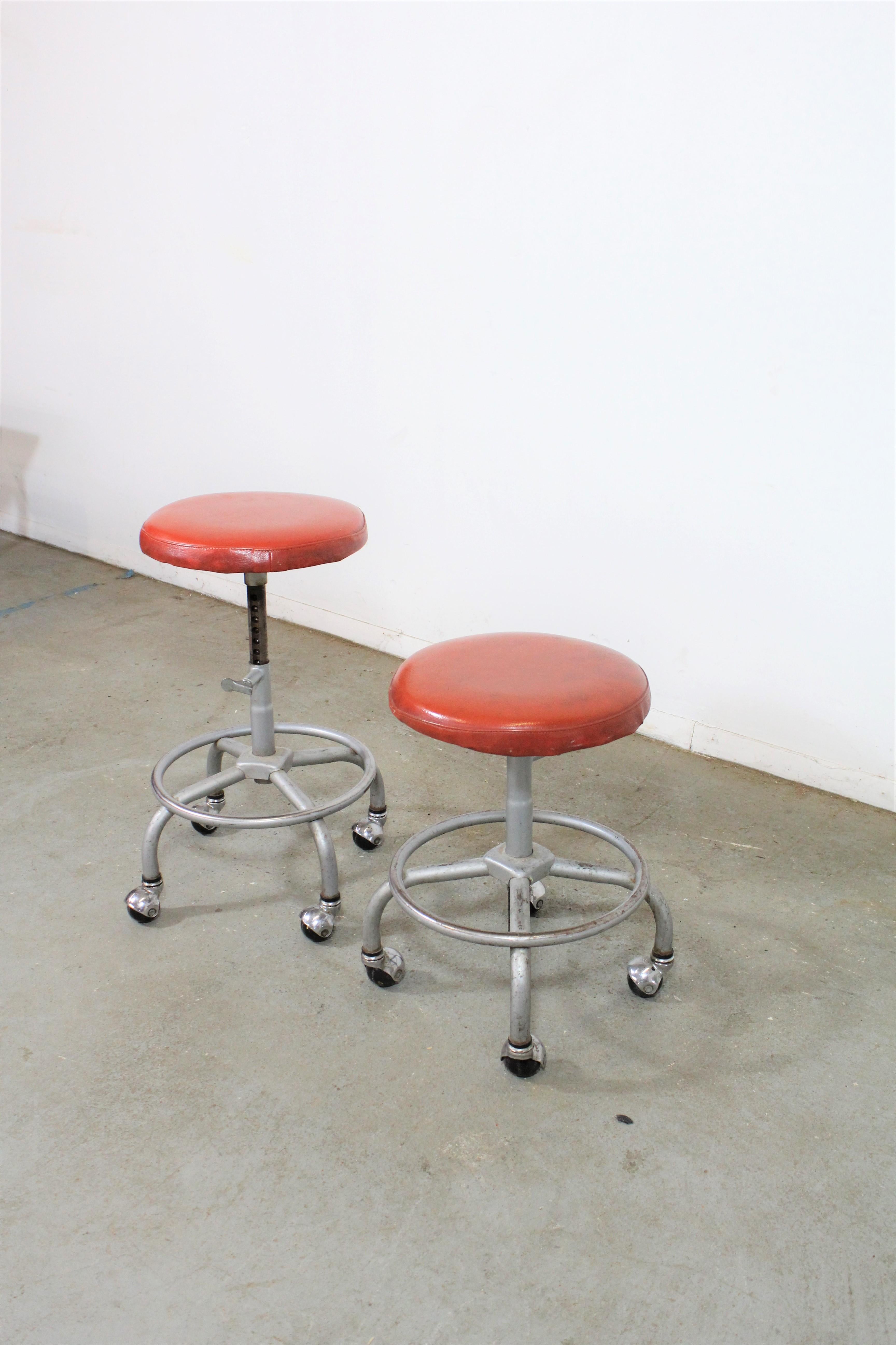 Pair of midcentury industrial swivel stools

Offered is a pair of midcentury industrial swivel stools. These stools are adjustable. The orange vinyl seats have staining and the chrome legs have patina. They are in good condition for their age,