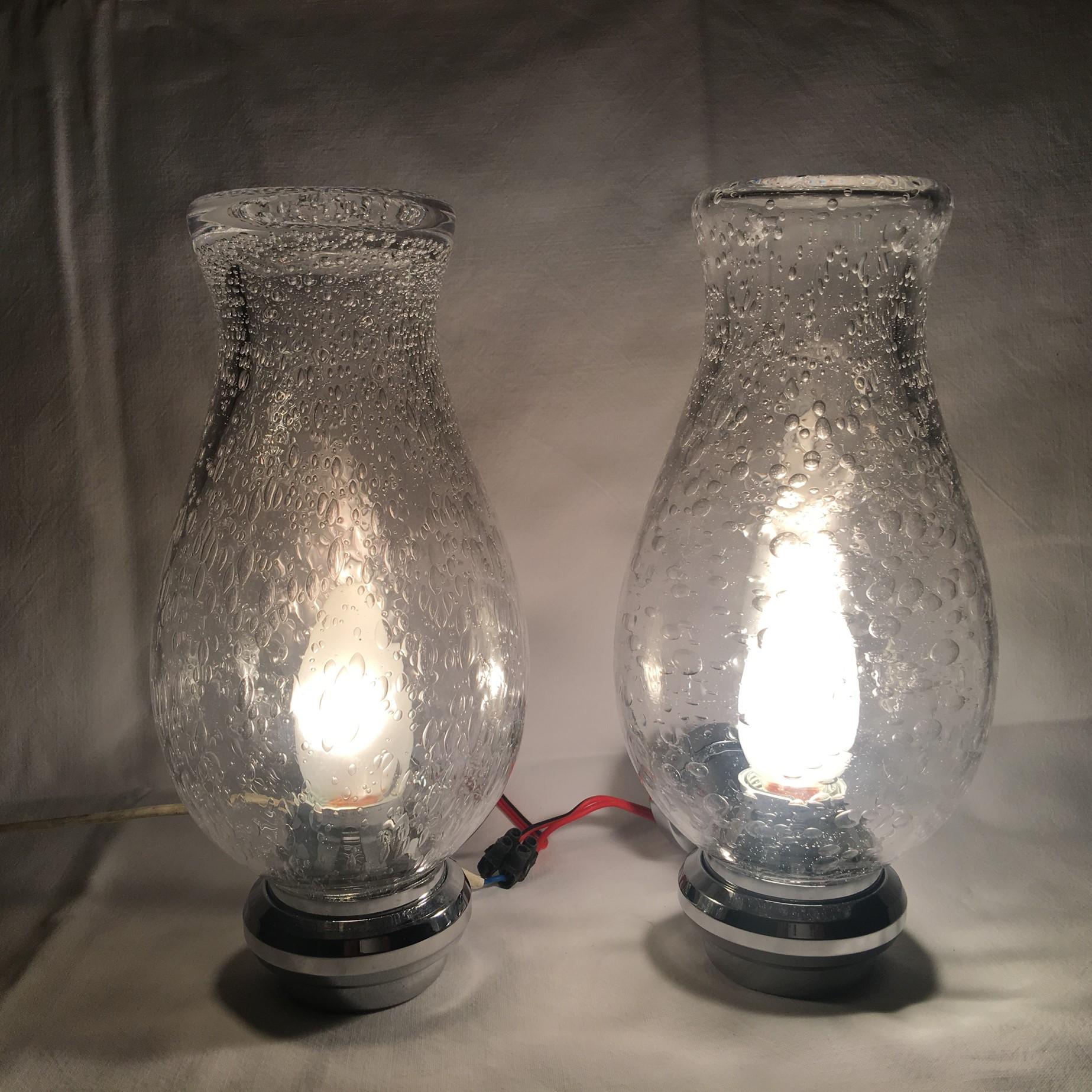 From the 1970s. A nice pair of chrome and bubble glass vanity sconces. Each fixture requires one European E 14 candelabra bulb up to 40 Watts max. Nice chrome and glass effect when lit.