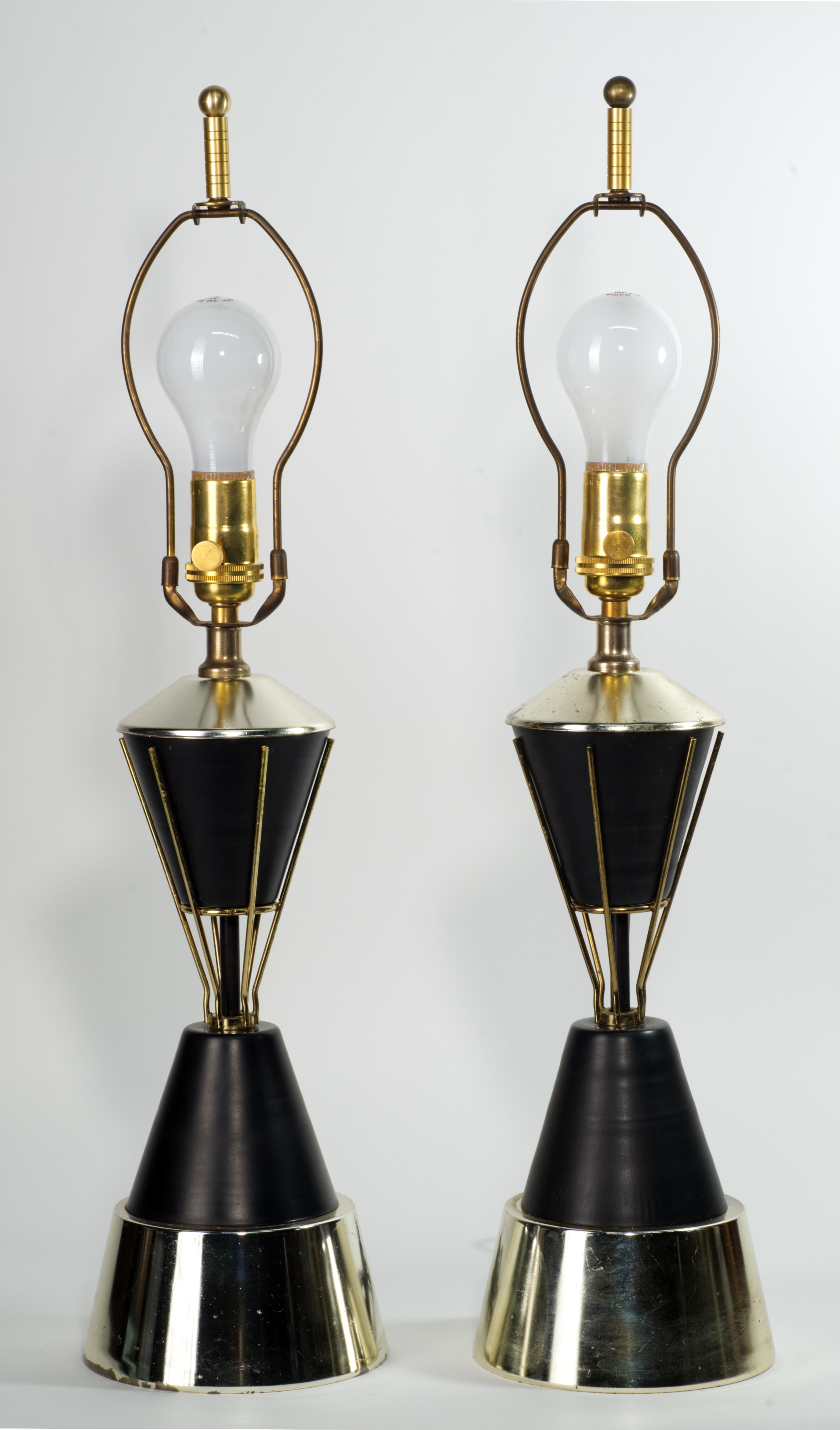 Rare paire sculpturale de lampes de table en laiton et émail noir, en forme de sablier avec des accents chromés graphiques dans la partie centrale ; de larges bases ajoutent de la stabilité aux pièces. Les lampes sont attribuées à Vitra Brass

Les