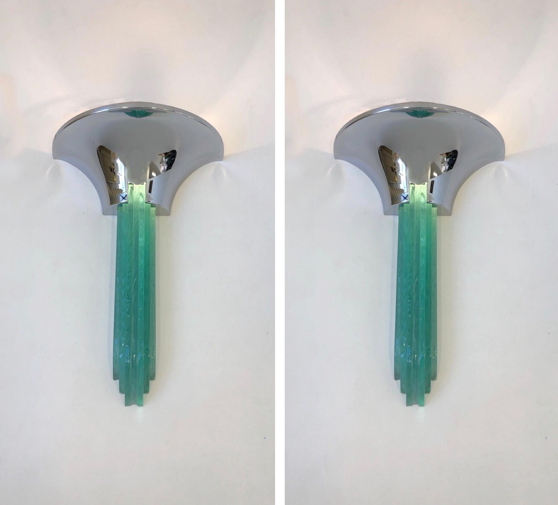 A spectacular pair of polish chrome and glass ‘Percell’ Wall Sconces design by Karl Springer in the 1980’s. The Sconces take two regular Edison lightbulbs.  One of the glass pieces has a small chip that is not seen when hung(See detail photo).