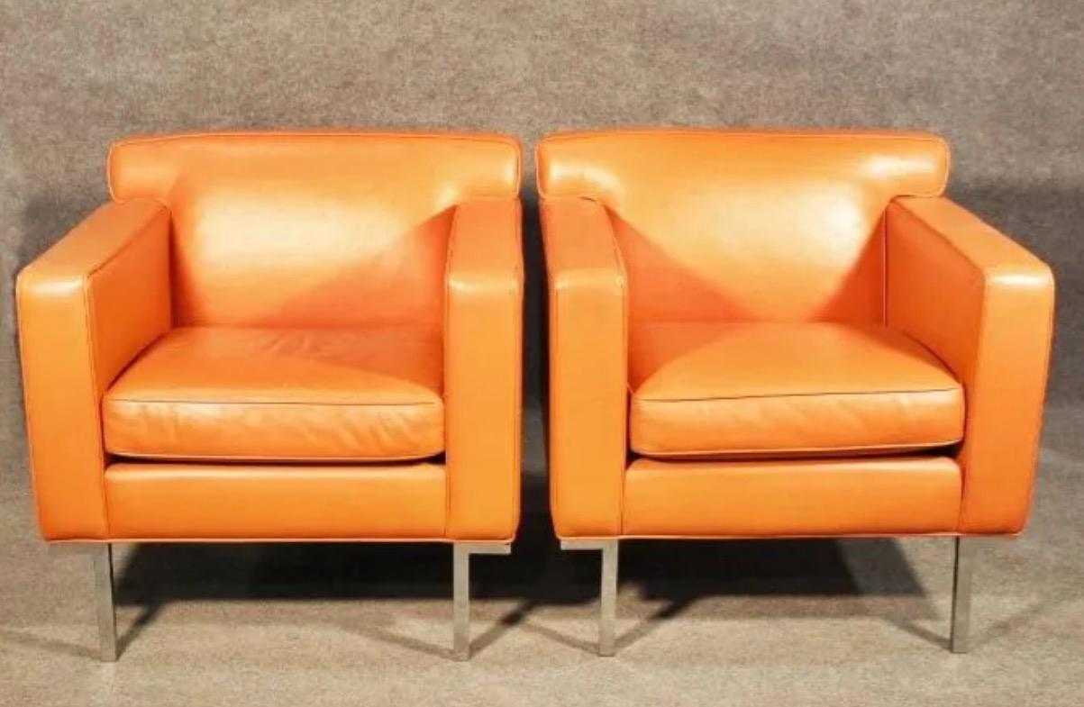 With a combination of vivid orange leather and a chrome frame, this pair of armchairs feature a comfortable and minimal design with a pop of color. Please confirm item location with seller (NY/NJ).