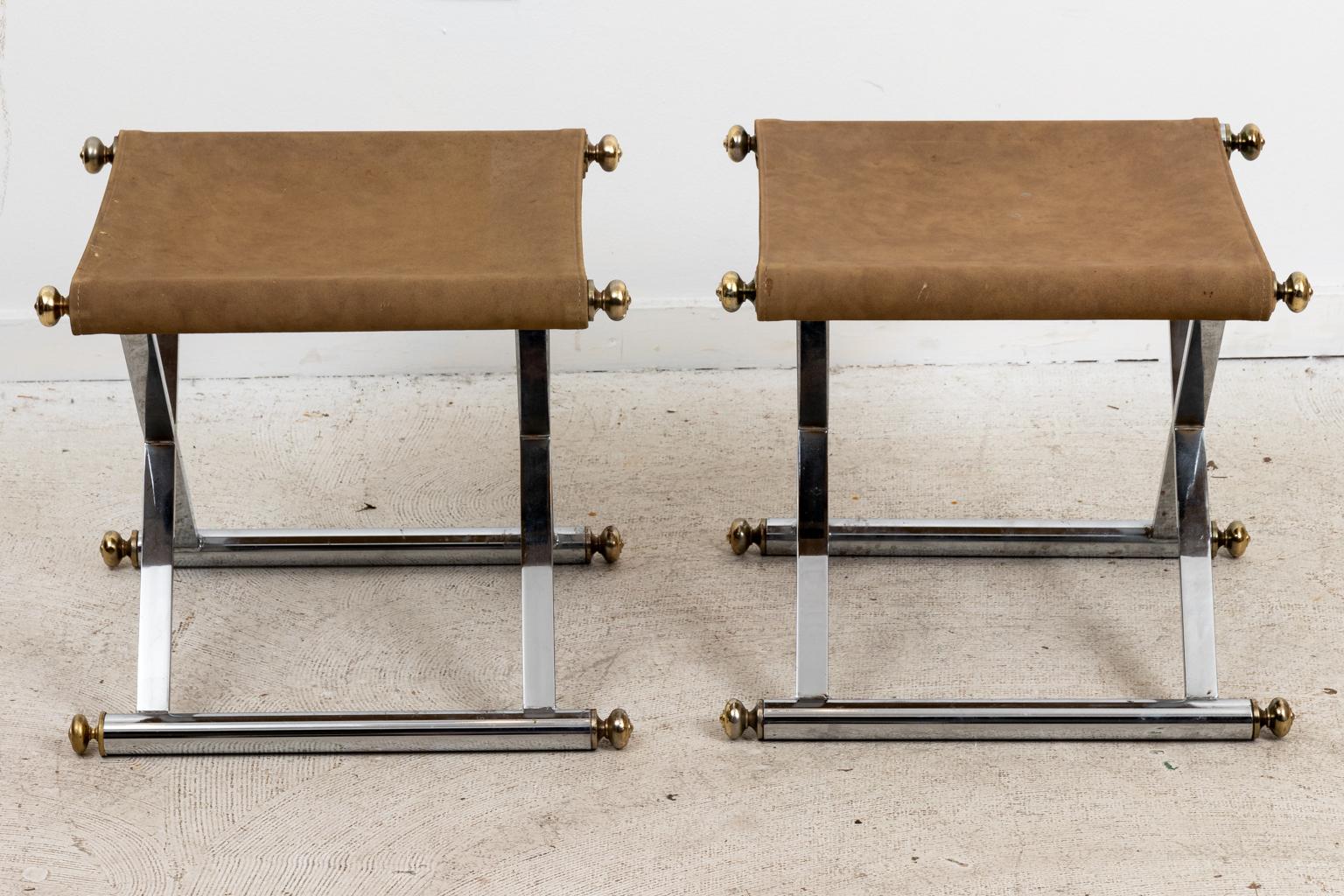 Circa 1970s pair of chrome and suede upholstered x-base benches with brass ball finials. Please note of wear consistent with age including replacement of one finial and minor patina.