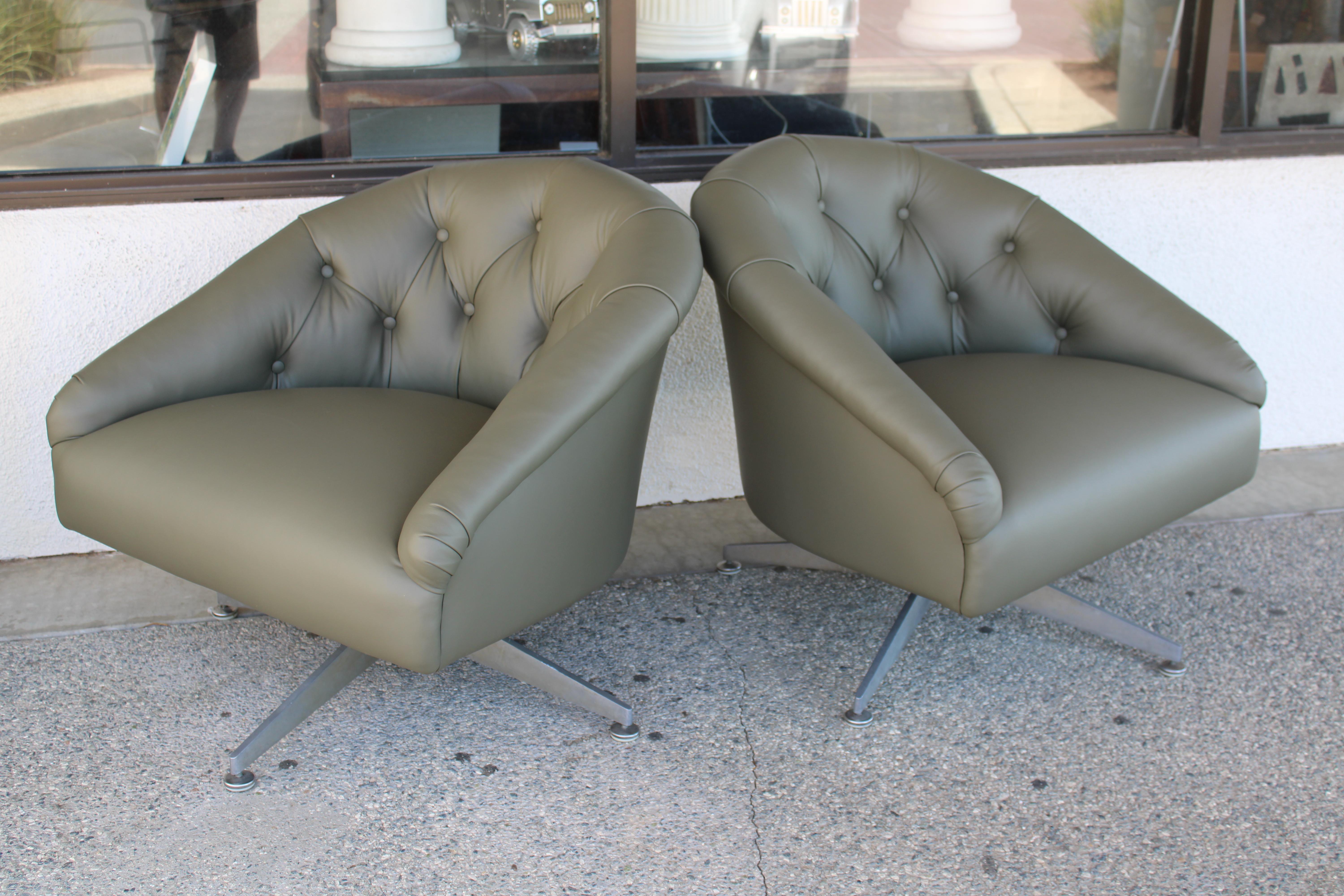 Pair of chrome and tufted leather swivel lounge / armchairs resting on a four leg brushed chrome pedestal base by Ward Bennett.  
