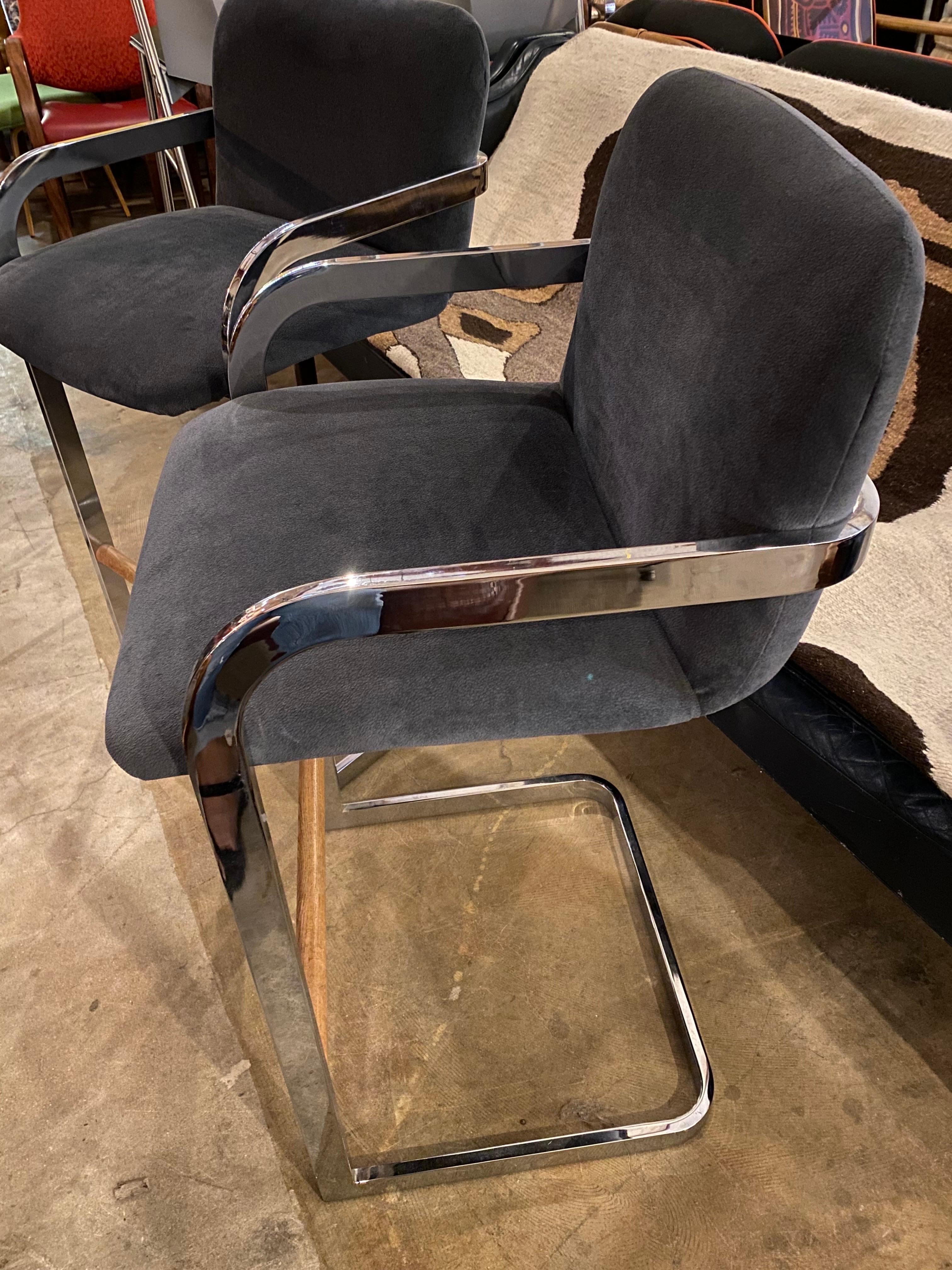 Great pair of cantilever-style bar stools designed by DIA (Design Institute America) features a chrome base with wood footrests. and the seating is upholstered in gray fabric. Barstools are in great overall condition. 

Measures: 21