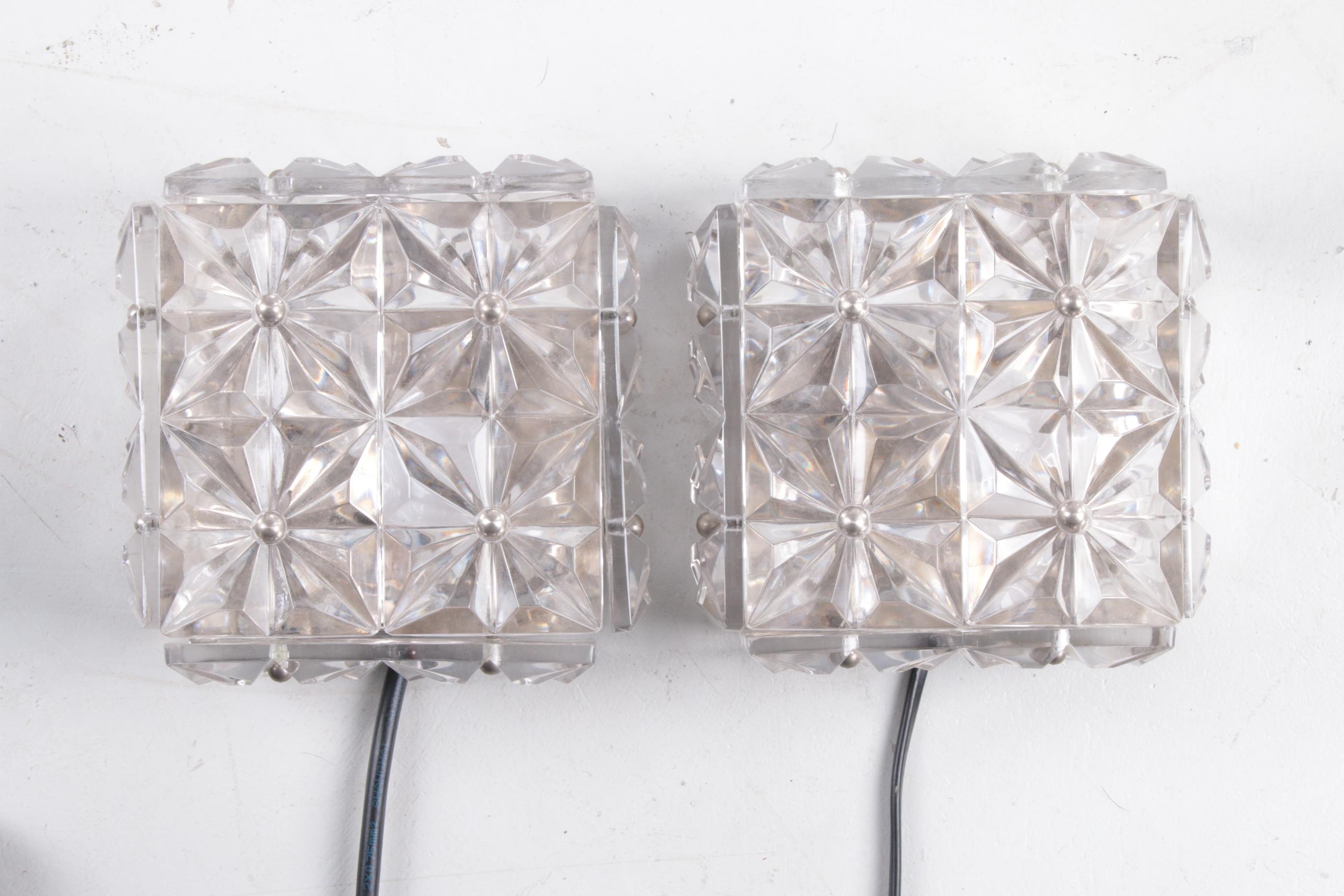 Pair of chrome & crystal glass wall lamps by Kinkeldey, 1970s

Pair of square lamps by Kinkeldey, Germany, manufactured in the mid-century, circa 1970 (late 60s or early 70s). A chrome frame holds 12 small square cut crystal lenses. They can be
