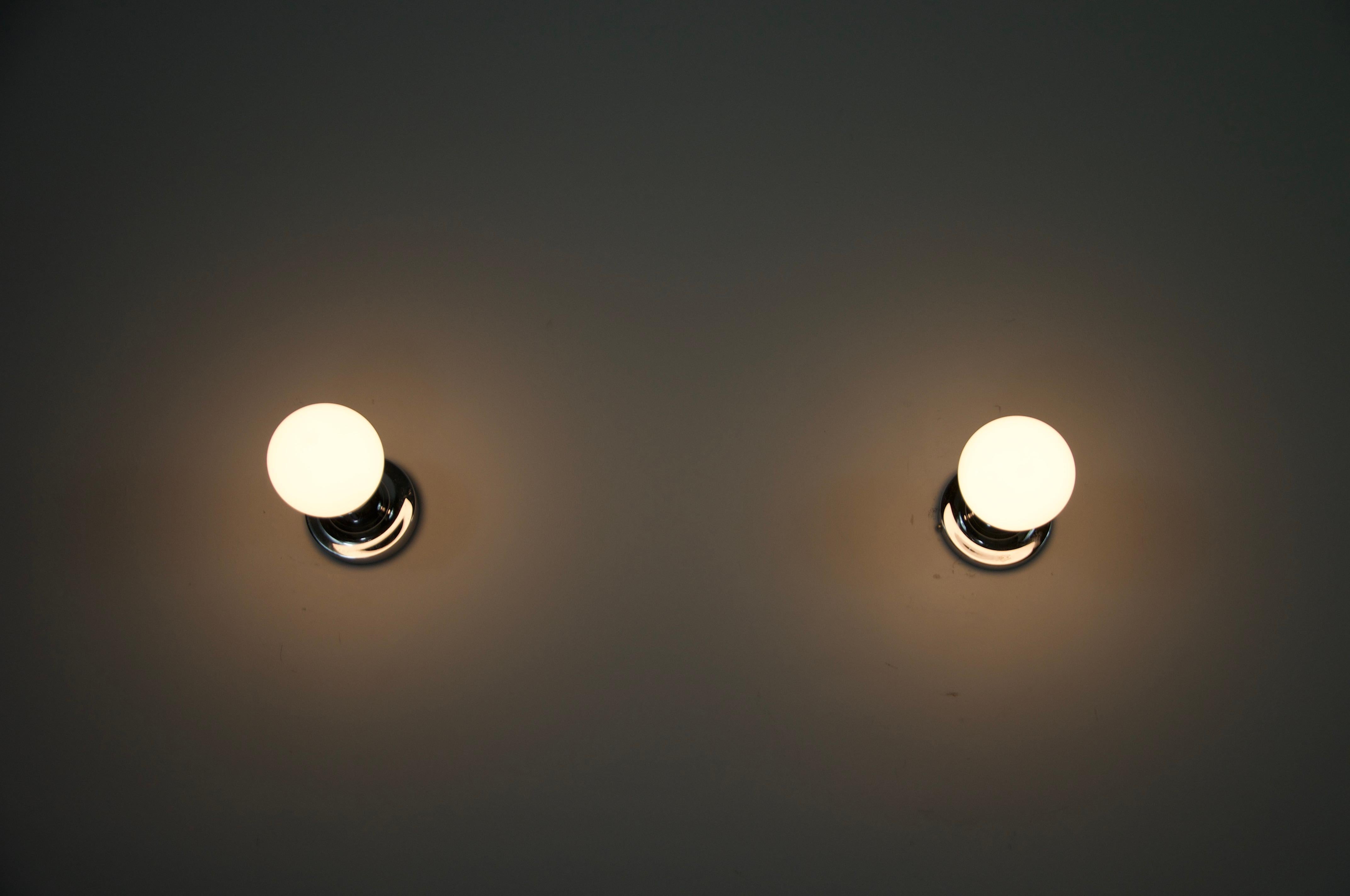 Questa coppia di lampade da parete a forma di disco cromato, risalente agli anni '60, è un esempio lampante del design dell'illuminazione moderna della metà del secolo. Il pezzo presenta un'elegante base circolare cromata dal profilo minimalista,