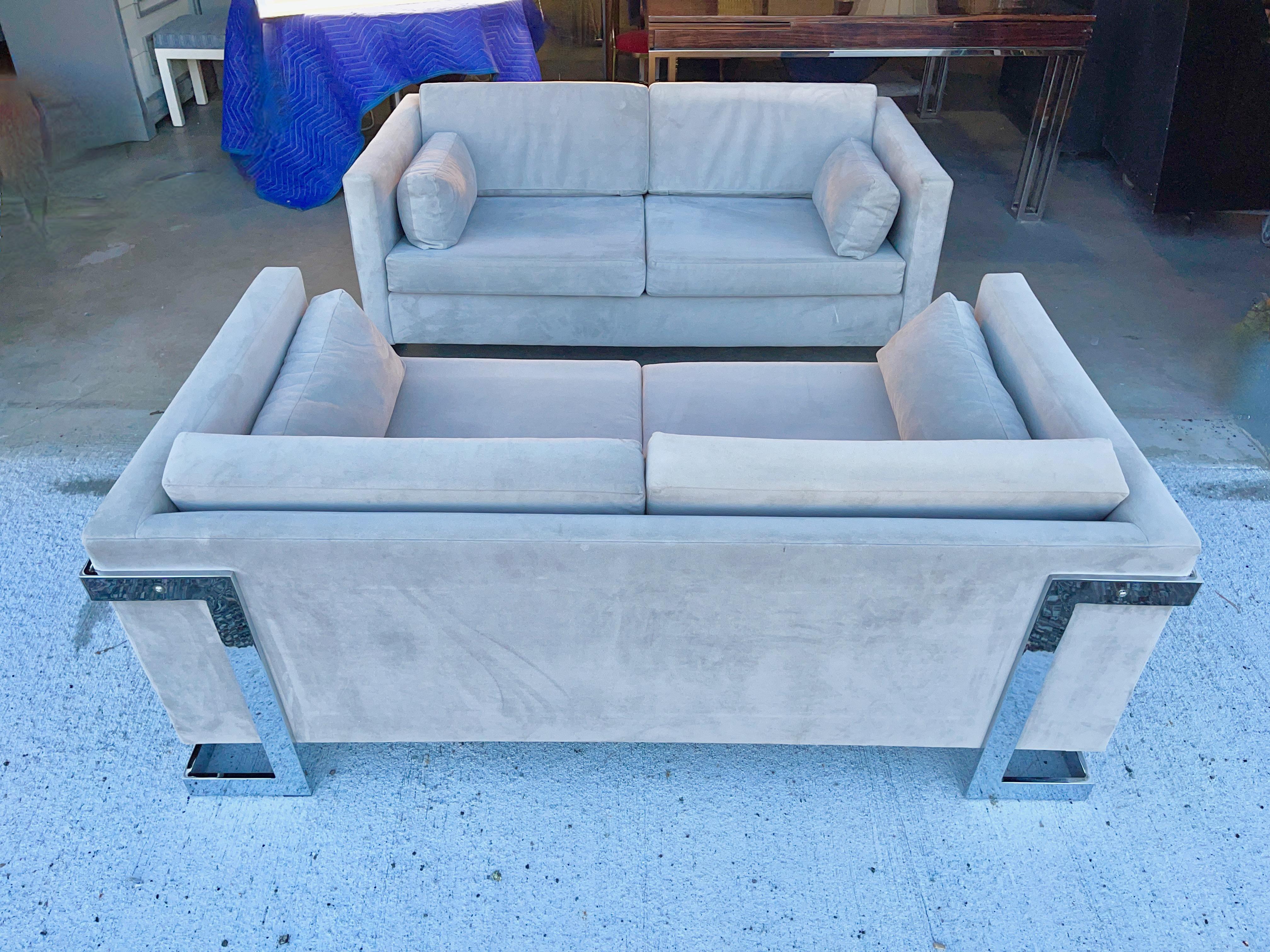 Pair of vintage 1970's chrome framed cantilevered loveseat sofas in the style of Milo Baughman and similar to seating groups of the period by Selig and Bernhardt's Flair division.
These have been reupholstered at some point in their life so no
