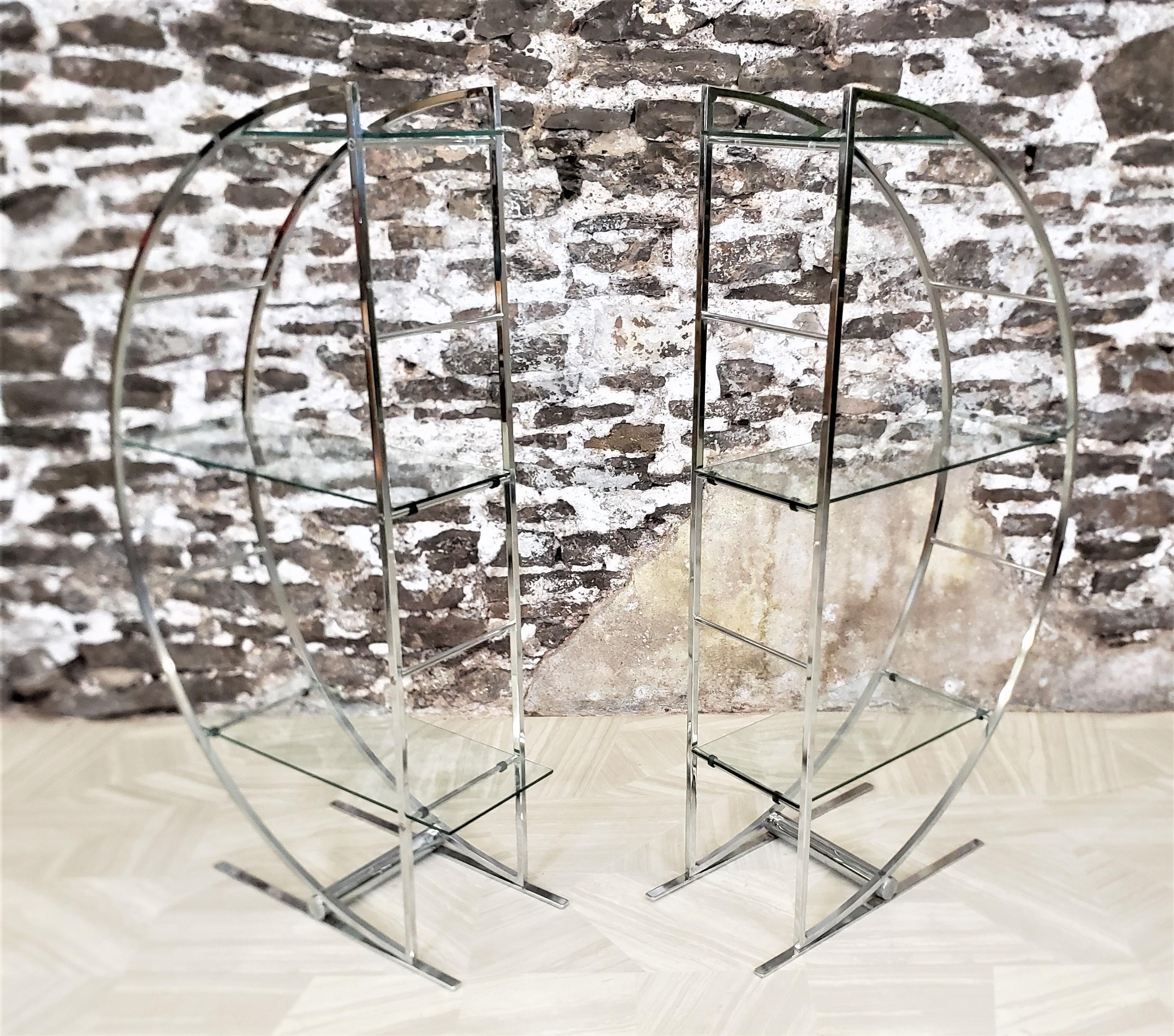 This pair of Mid-Century Modern era chrome and glass half moon shelves bear no maker's signature, but are believed to have been made in the United States in an Art Deco style. The shelves are made of chromed metal and done in a ladder back fashion,