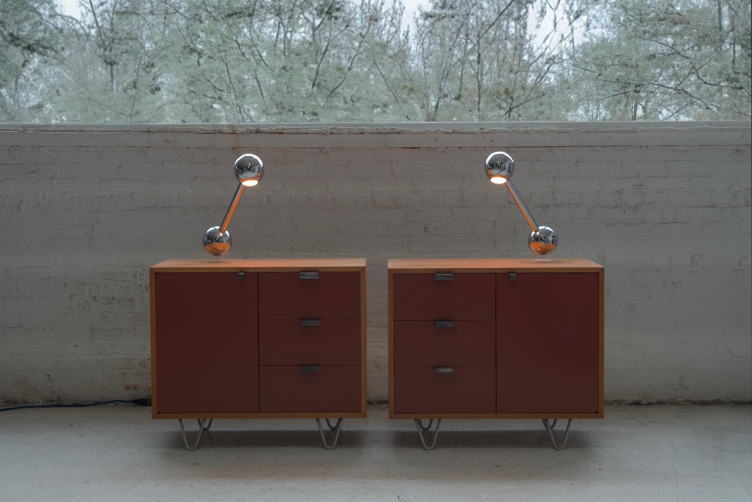 Pair of chrome plated Barbell Lamps by John Mascheroni.  The lamps have a heavy counter weight in the bottom that rests in an acrylic stand. The lamps can swivel freely in the stand and when tilted, the light turns on and when put back in an upright