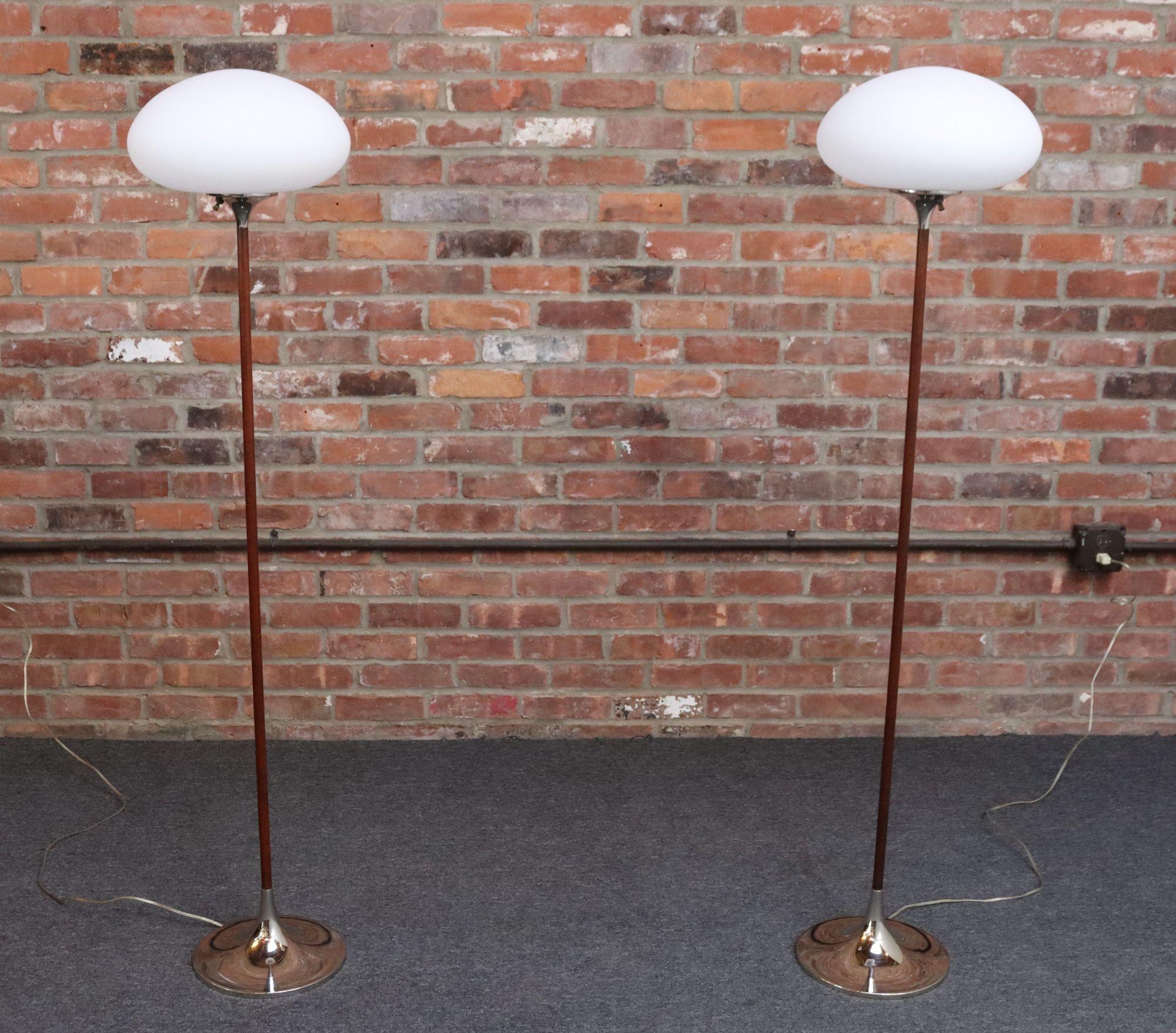 Pair of elegant and iconic floor lamps by Laurel Lamp Co. (ca. 1960s, Newark, NJ, USA).
Composed of a walnut stems supporting frosted glass mushroom-form shades with sculptural chrome accents (base and neck).
Glass emits the warmest, most attractive