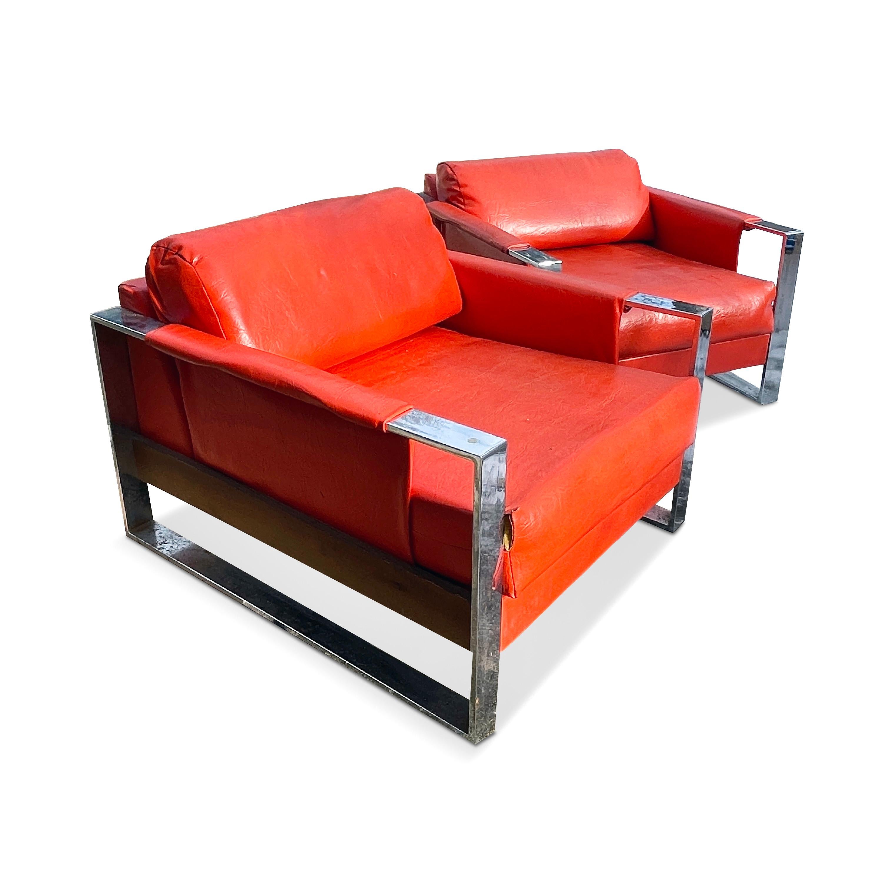 A rare pair of Mid-Century Modern chrome armed lounge chairs by Adrian Pearsall for Craft Associates with orange vinyl upholstery and wood accents. With a deep seat, thick padding, and well-designed proportions, this pair are extraordinarily