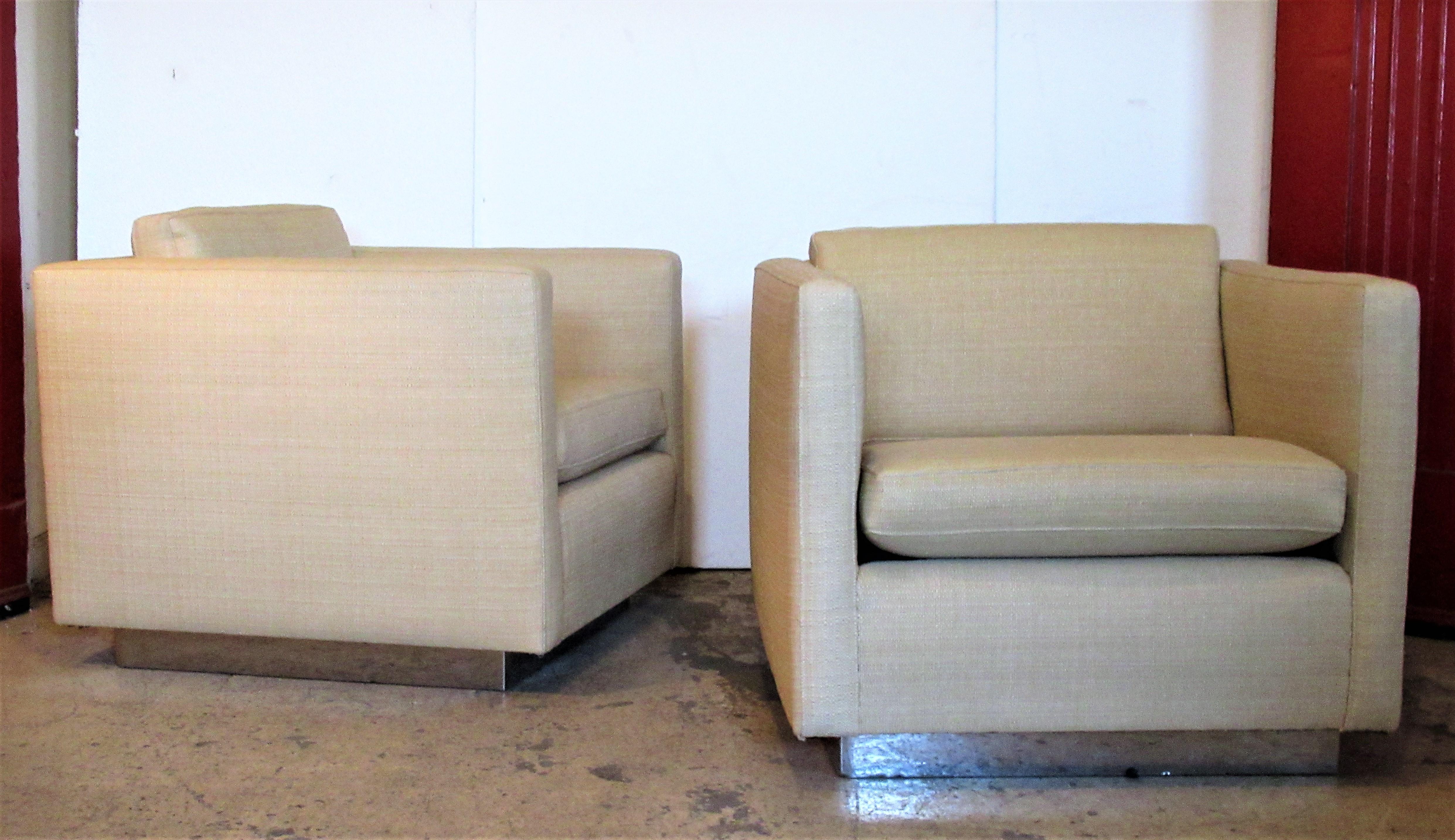 Pair of big chrome clad platform base cube lounge chairs having a floating form and a very tailored sophisticated look. The chairs were upholstered within the past ten years in a beautiful commercial grade natural straw colored textured grass cloth