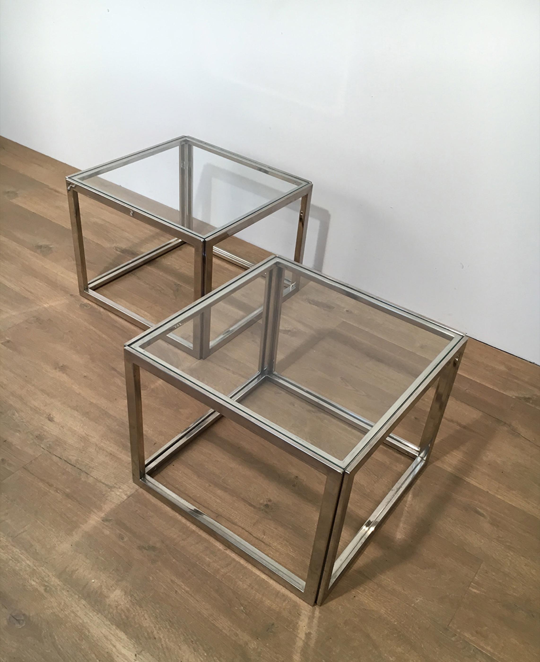 This pair of side tables is made of chrome with clear glass. This is a French work, circa 1970.