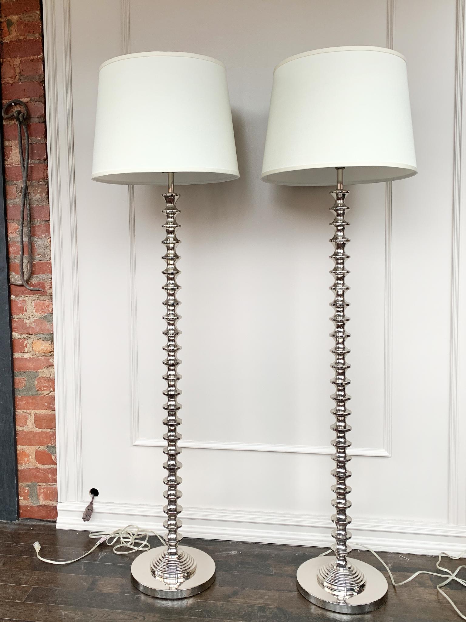 These chrome floor lamps are a modern take on the turned wood spool lamp. Newly rewired, single bulb socket. Paired with new linen shades.

Dimensions:
64 in. height
11.5 in. base diameter
18 in. shade diameter

Condition notes:
In good