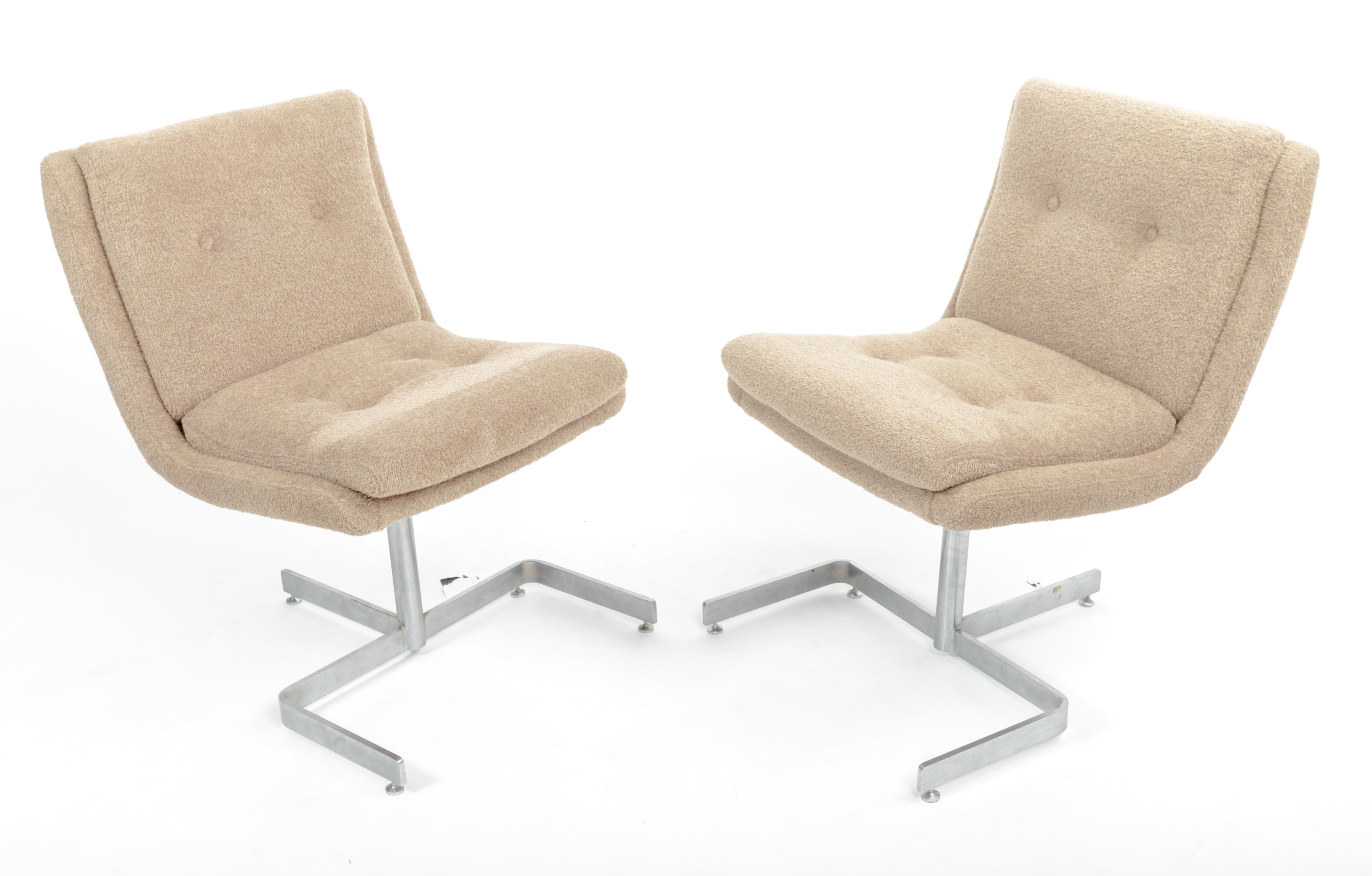 Exceptional pair of lounge chairs by acclaimed furniture designer Raphael, France, c. 1970s. 

Clean and elegant chair construction consists of a sleek three-pronged chrome-plated steel base, button-tufted cushions, and brand new upholstery in a