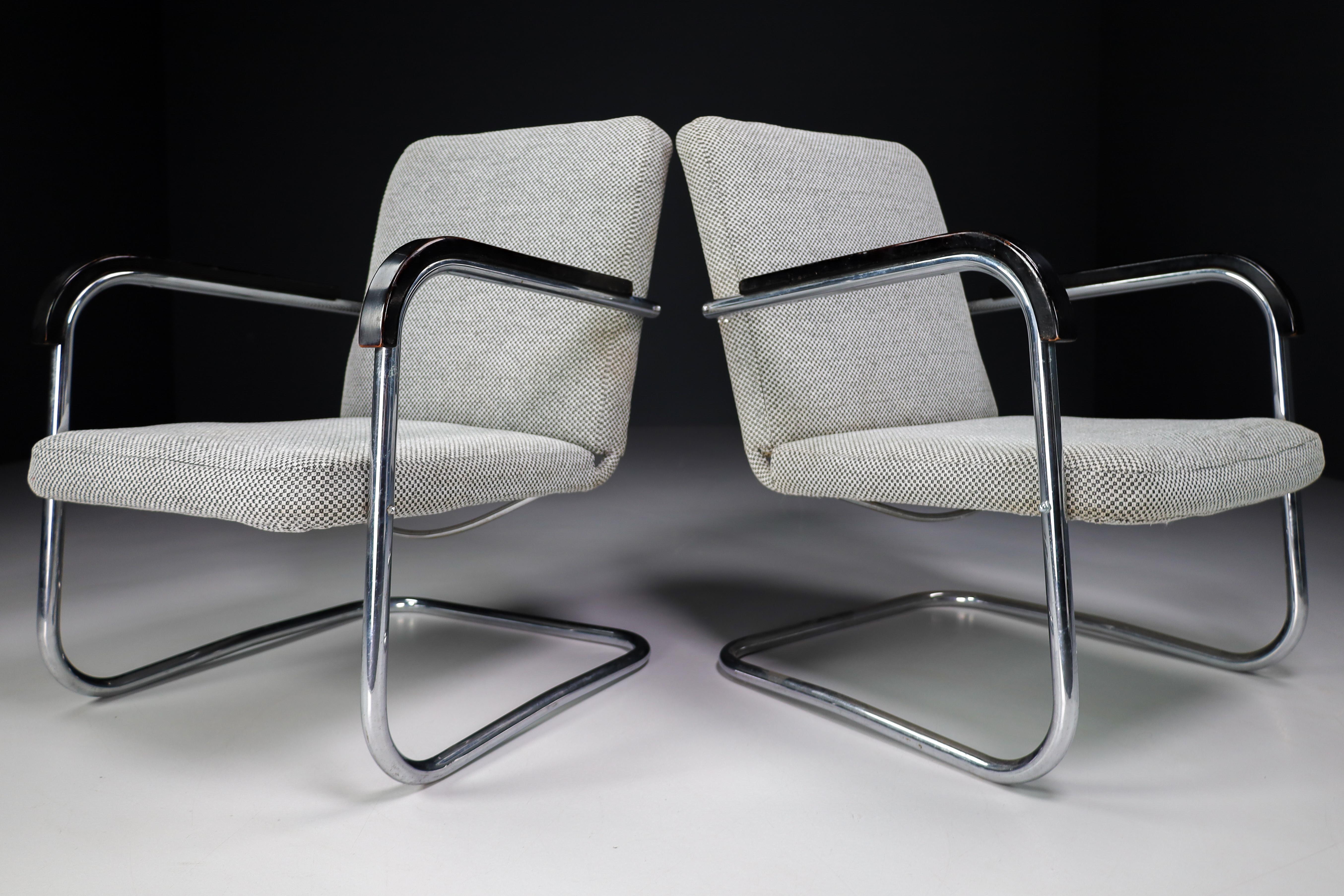 Pair of armchairs by Thonet circa 1930s midcentury Bauhaus period. These cantilever armchairs are typical for the German and Eastern Europe Bauhaus era. These armchairs has a tubular steel frame and is Re-upholstered with a grey fabric. The original