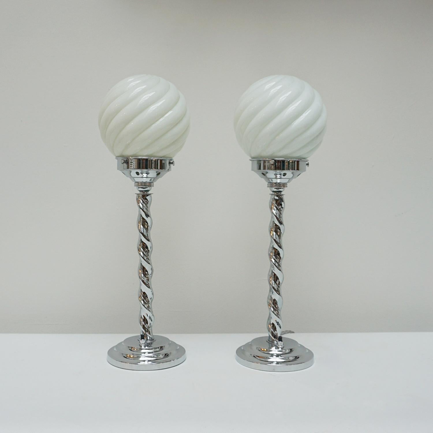 A pair of Art Deco table lamps. Chromed metal barley twist stem, set over stepped circular base. White spiral globe shades. 

Dimensions: H 49cm 

Origin: English

Item Number: J292

All of our lighting is fully refurbished, re-wired, and re-chromed