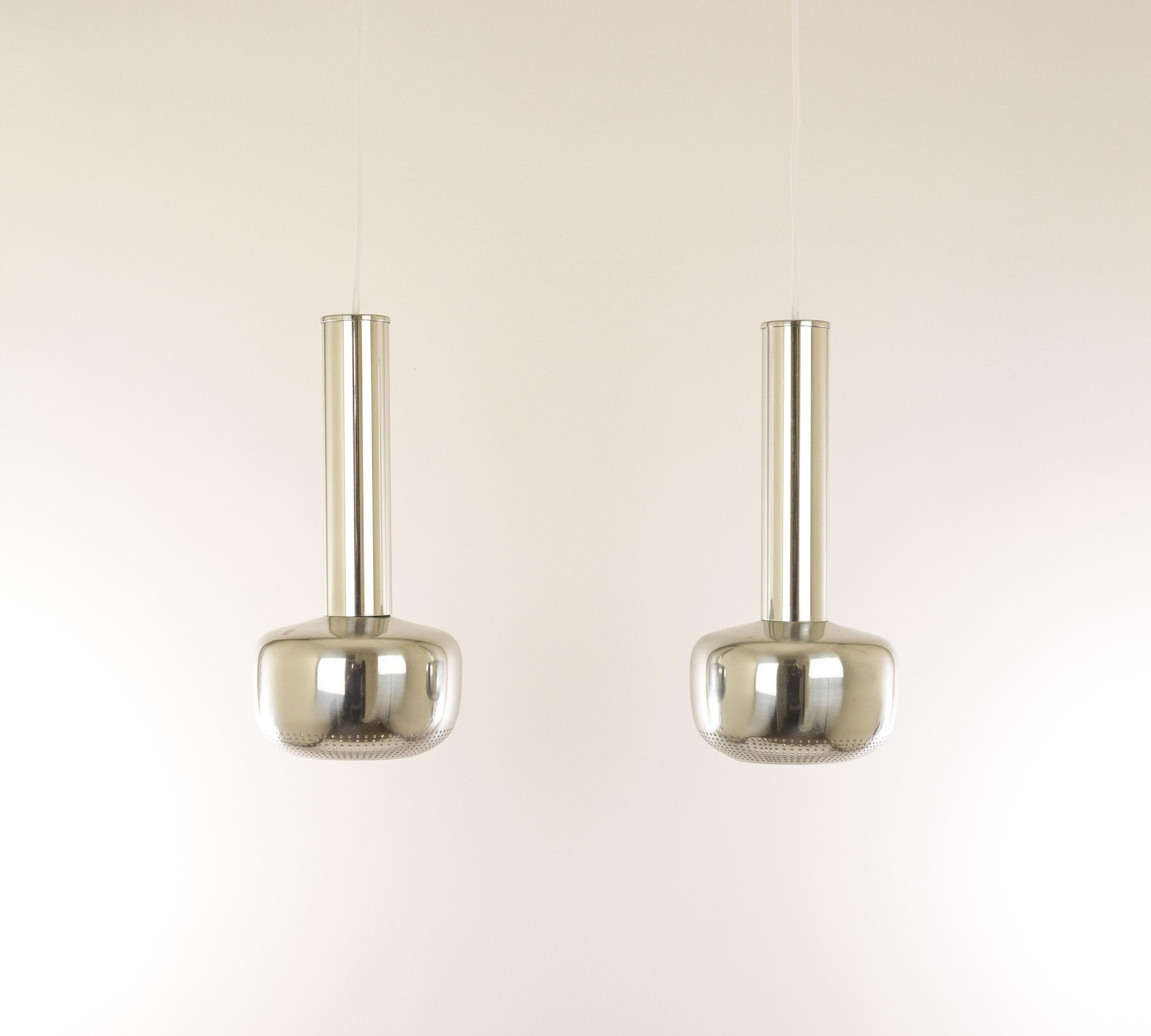 Pair of Guldpendel designed in 1956 by Vilhelm Lauritzen for Louis Poulsen. A pair of chromed aluminium pendants consisting of a cylindrical top and a perforated reflector at the bottom. Originally the Guldpendel was designed with a brass lacquered