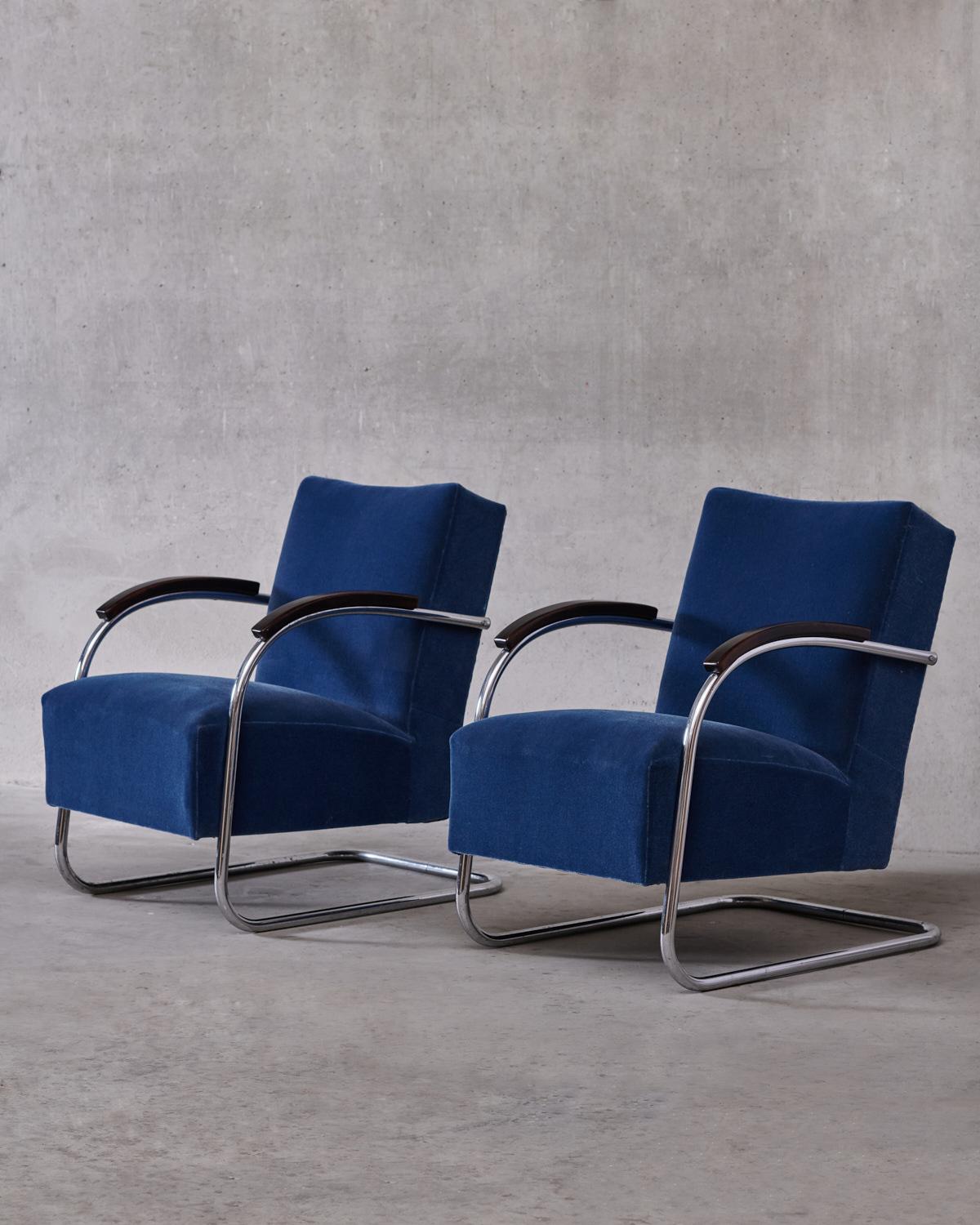 Pair of cantilever Art Deco armchairs in tubular steel with new dark blue mohair fabric covers. The original design of the FN 21 Famos model was made by Mücke & Melder in 1930. The armrests are made of stained beech. 

Mucke Melder began producing