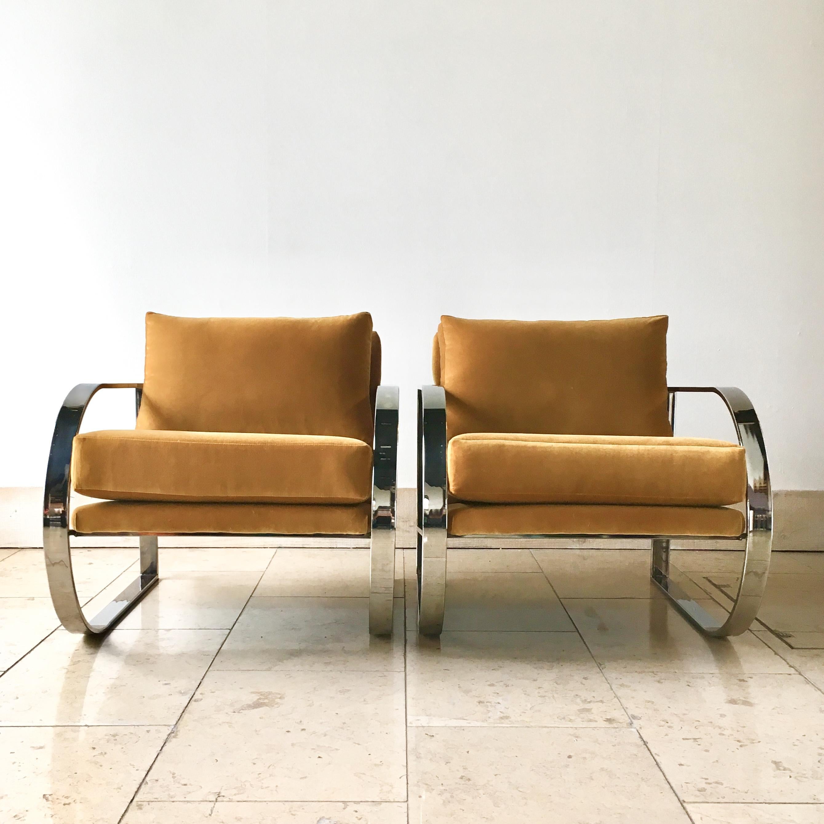 Pair of curved chromium steel framed armchairs upholstered by our team in a mustard coloured velvet. 1970s  
  
