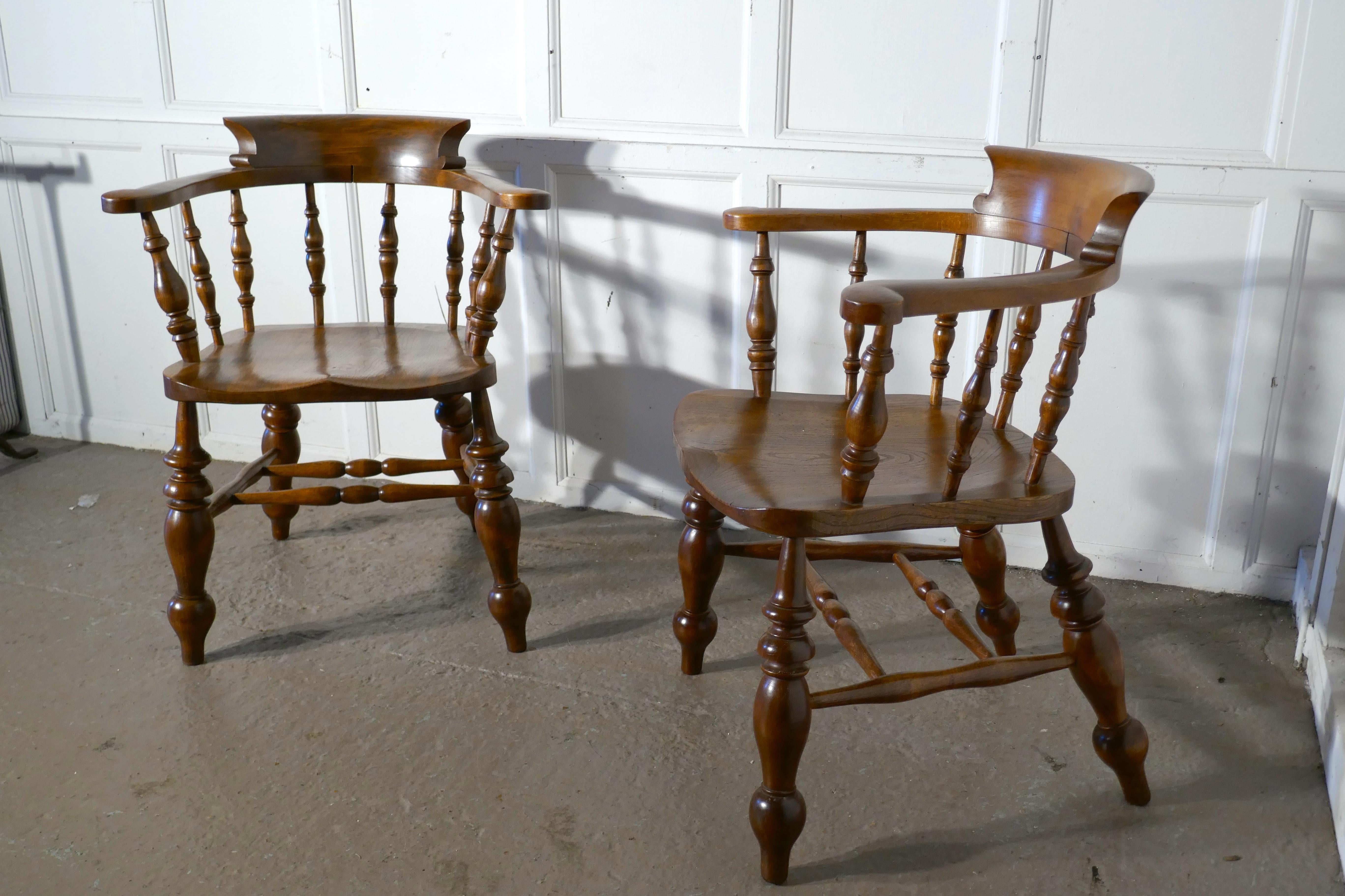 A pair of chunky elm smokers bow office or desk chairs

These large solid elm and beech chairs have attractive curving backs with a very wide curved top rail and turned spindles beneath 

The chairs stand on chunky, sturdy turned legs and have